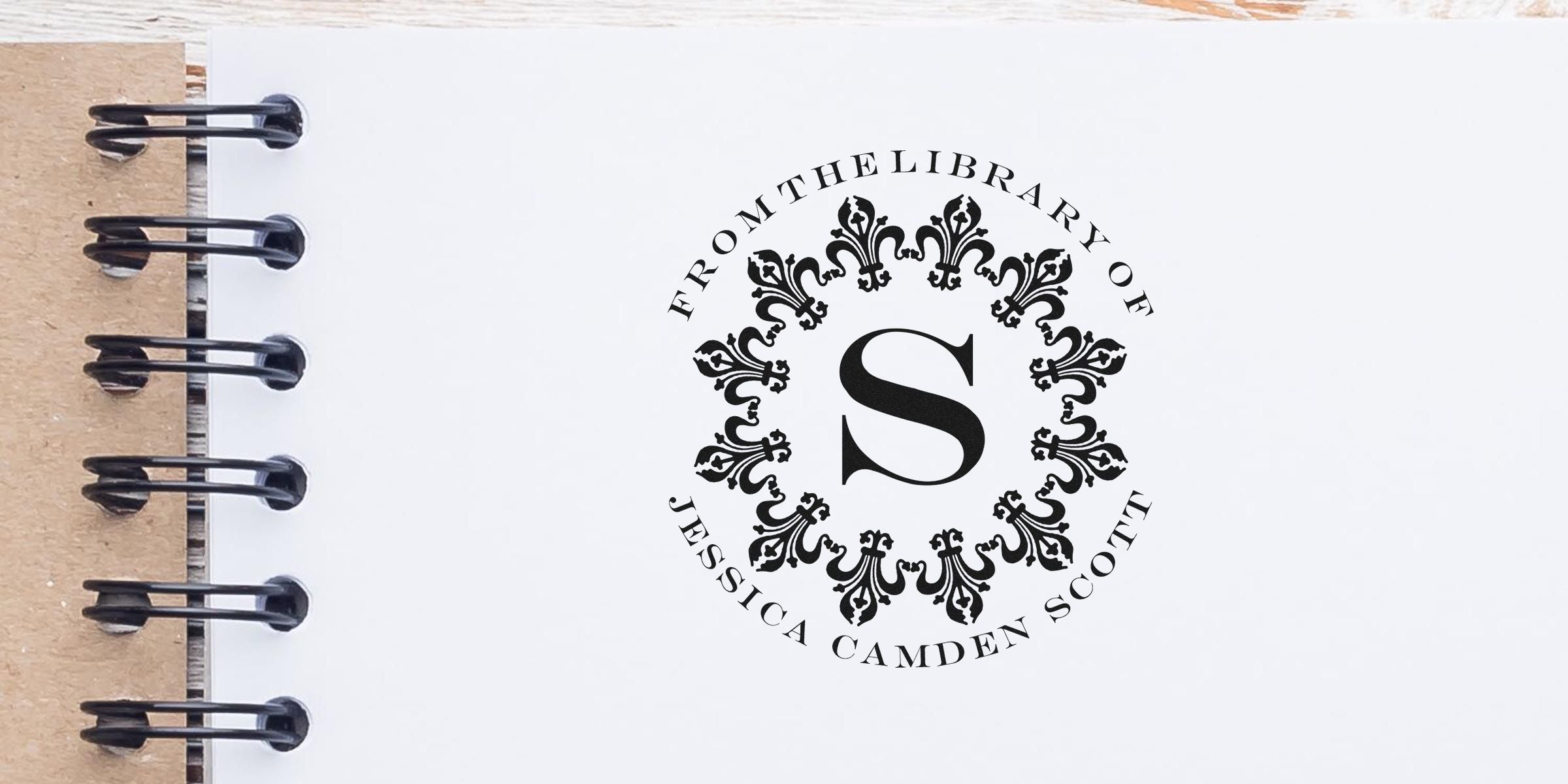 Ornate circular emblem with a large central letter “S,” surrounded by decorative black pattern and the text “From the Library of Jessica Camden Society.”