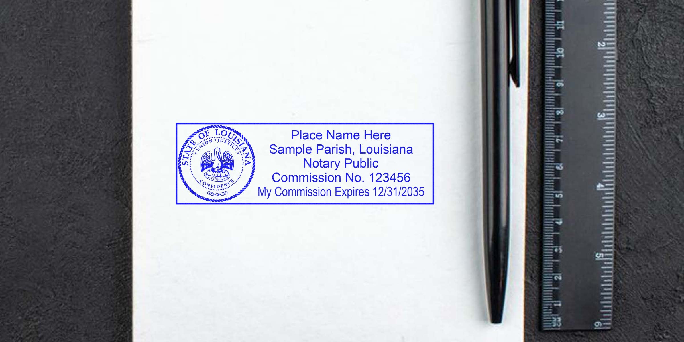 Blue Louisiana notary stamp imprint on white paper showing sample parish, commission number and expiration, photographed beside a black pen and ruler for scale — notary seal, notary public stamp, legal document accessory.
