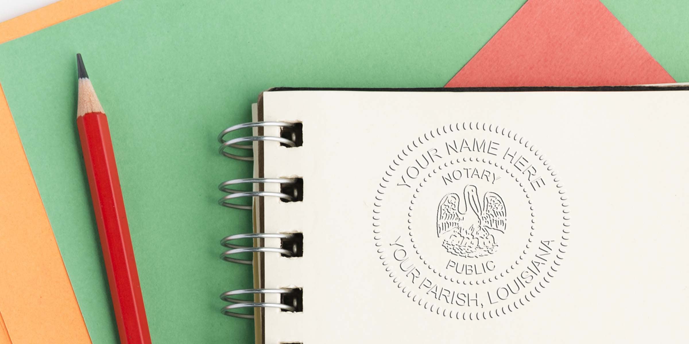 Spiral notebook page with embossed notary public seal reading "Your Name Here, Your Parish, Louisiana" beside a red pencil on layered green, orange and coral paper background