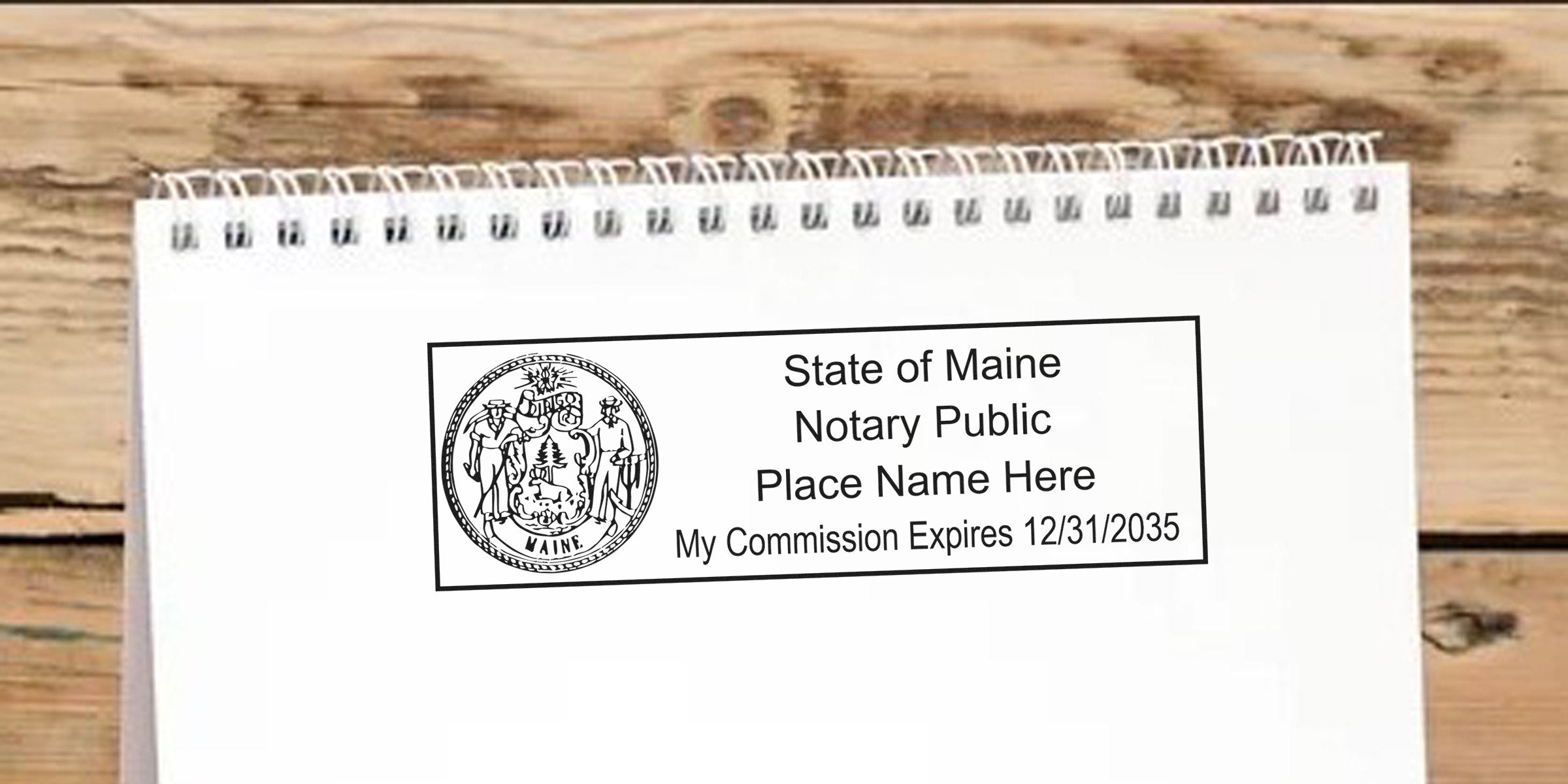 State of Maine notary public stamp on white spiral notebook page showing Maine state seal, placeholder name and commission expiration date 12/31/2035