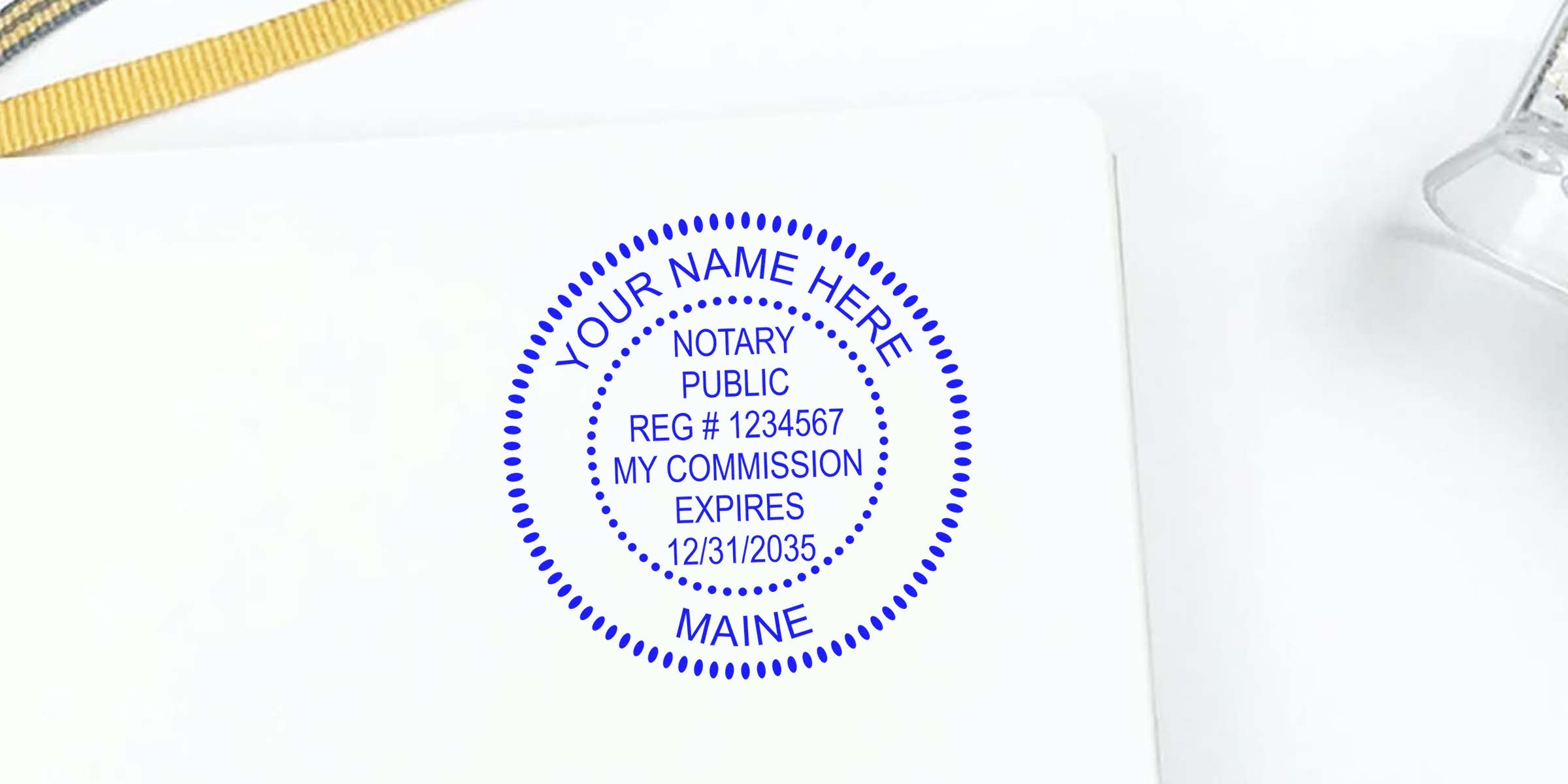 Blue circular notary public seal stamp on white background reading "Your Name Here," registration number, commission expires date, Maine.