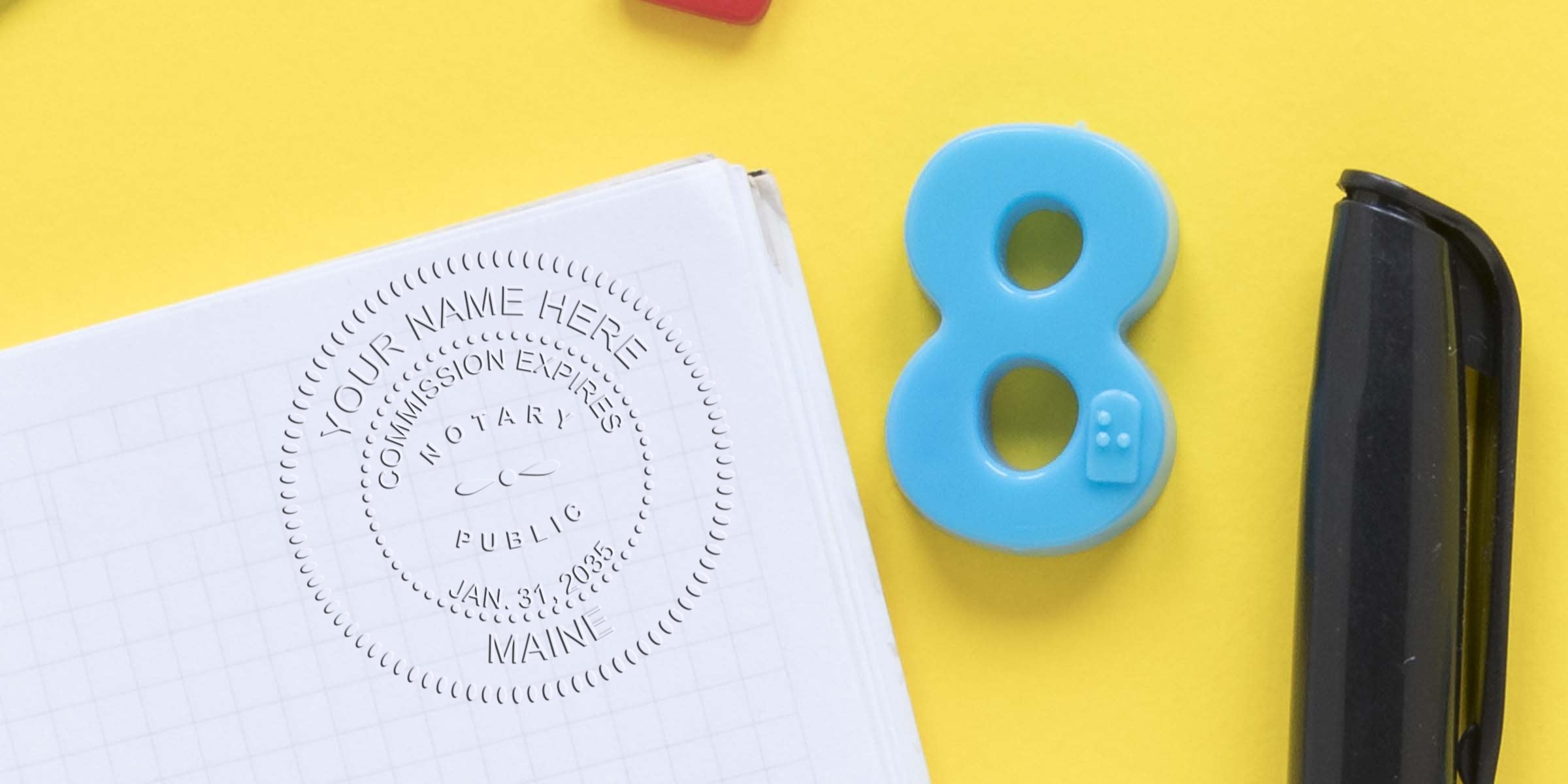Notary public embossed seal on graph paper next to a blue number 8 magnet and black stapler on a bright yellow background, office supplies flat lay, notary stamp impression, legal document accessory