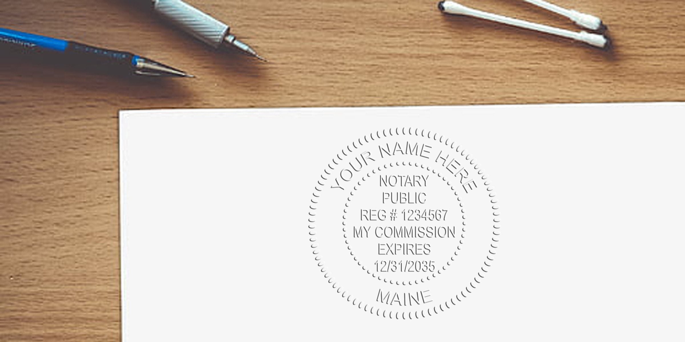 Embossed circular notary public seal stamped on white paper reading "Your Name Here," with pens and cotton swabs on a wooden desk