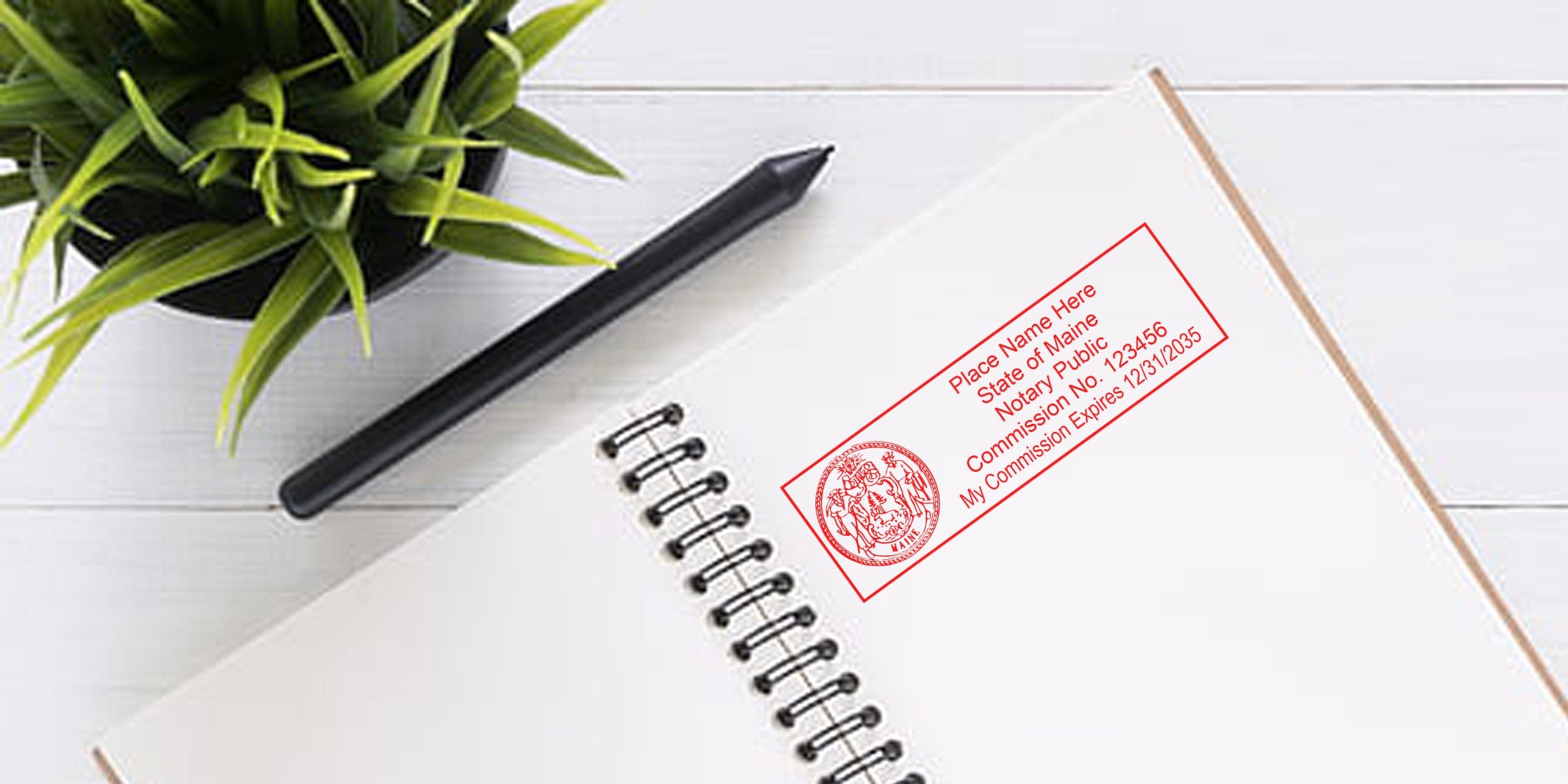Top-down photo of a blank spiral notebook with a red notary stamp, black pen and potted green plant on a white wooden desk — workspace flat lay, office stationery, notary seal.