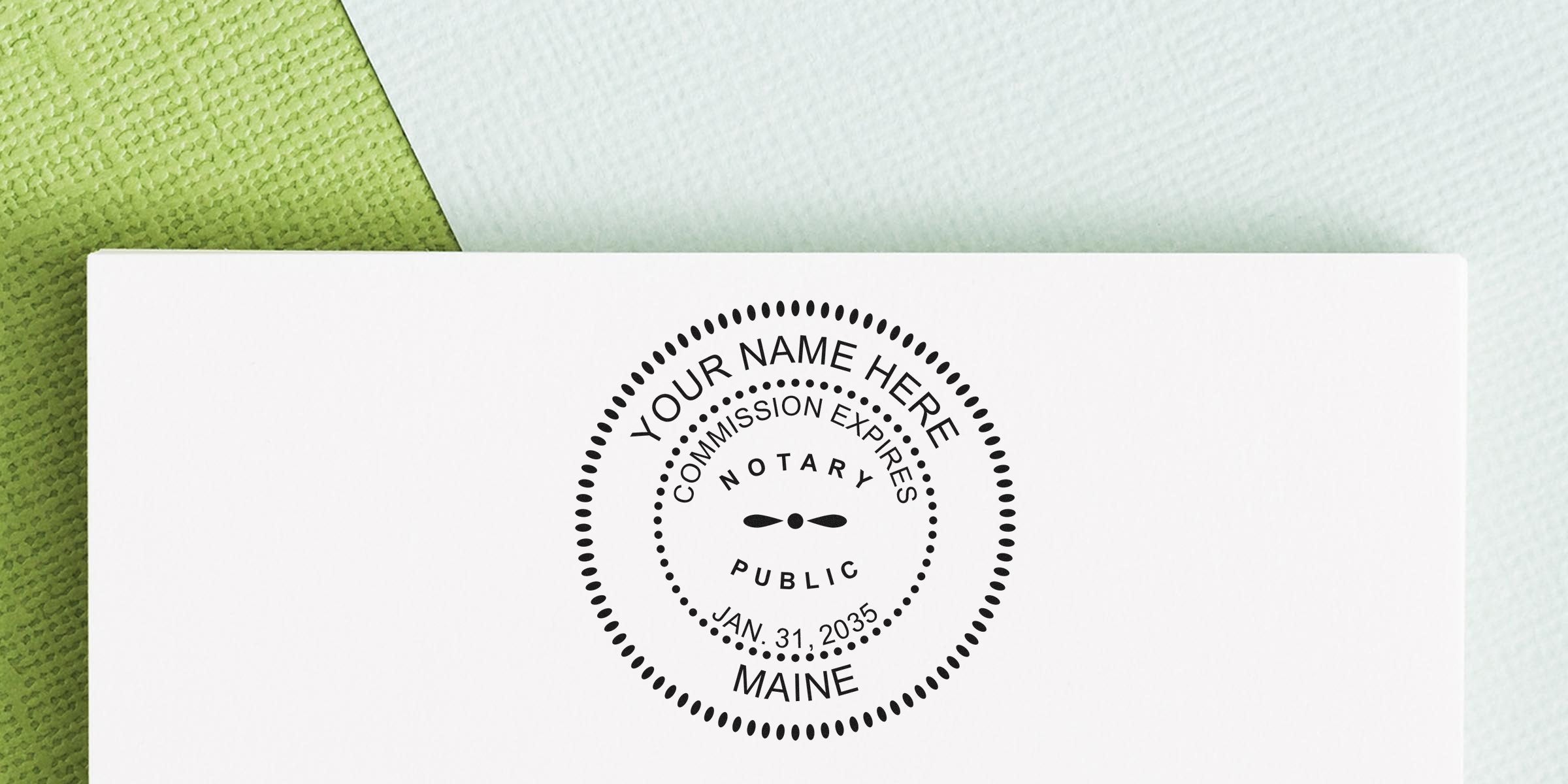Custom Maine notary public round stamp mockup on white card with green textured background, placeholder text "Your Name Here," "Notary Public," and commission expiry date Jan. 31, 2035 — ideal for customizable notary seal listings.
