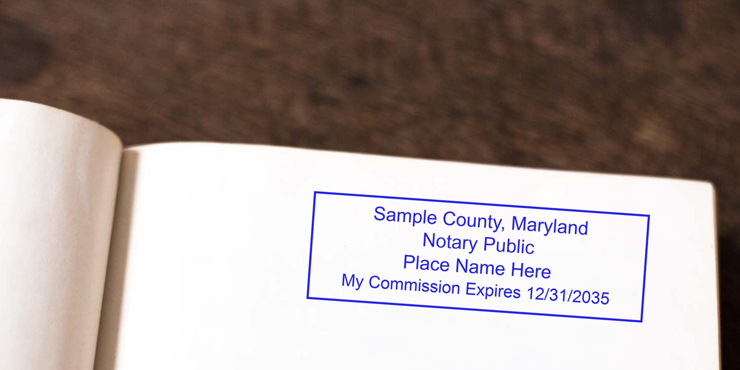Blue rectangular notary stamp on a blank book page reading "Sample County, Maryland Notary Public Place Name Here My Commission Expires 12/31/2035."