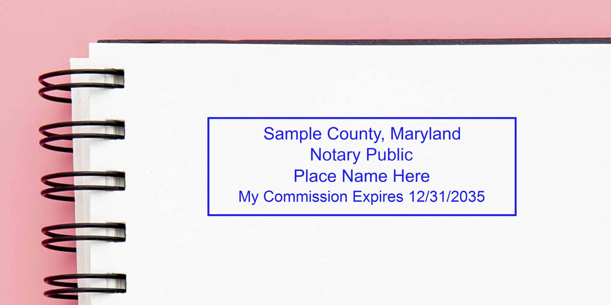 Blue notary public stamp on white spiral-bound notebook against pink background reading "Sample County, Maryland – Notary Public. Place Name Here. My Commission Expires 12/31/2035."
