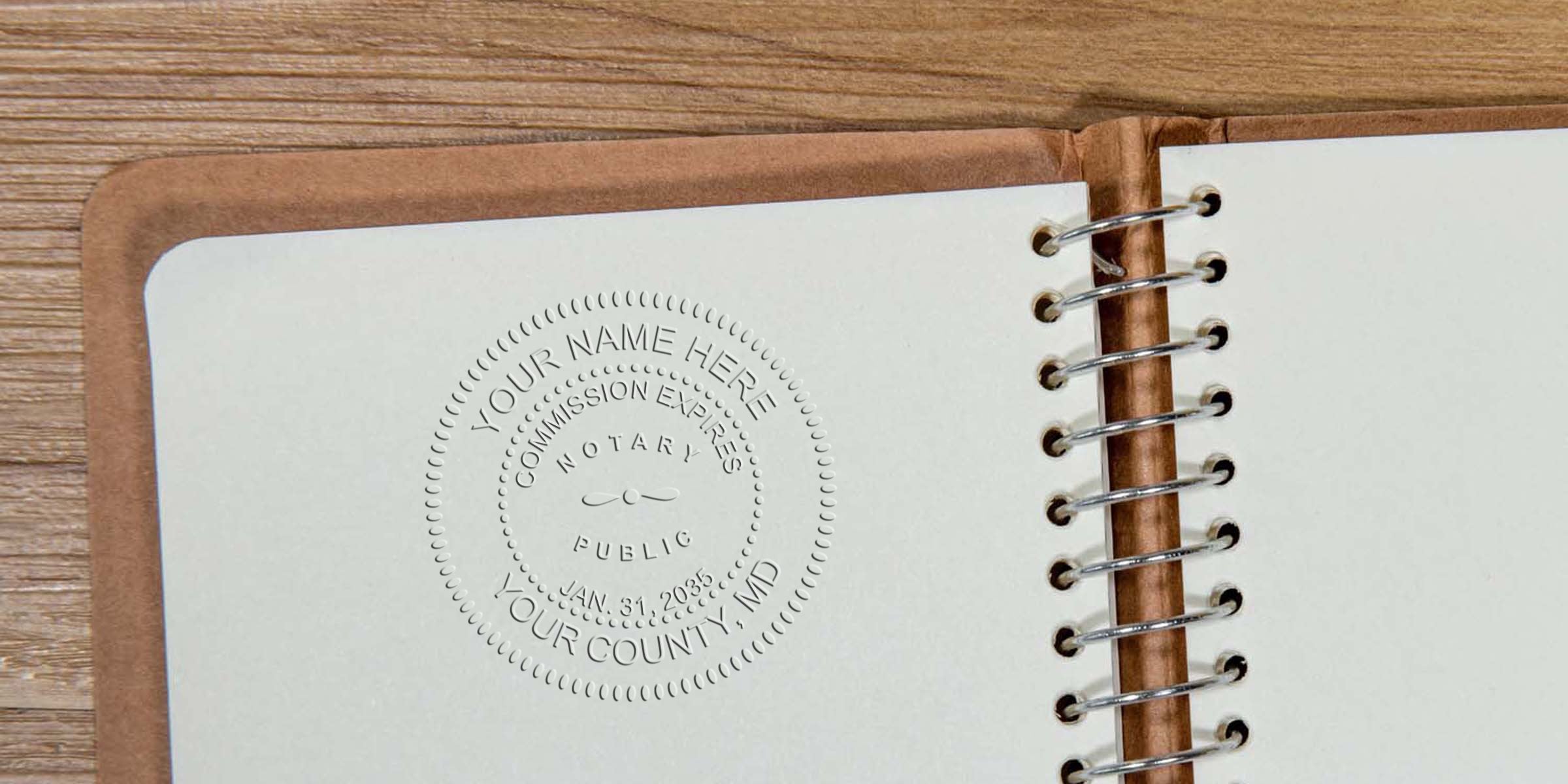 Close-up spiral-bound notebook opened to a blank cream page with an embossed circular notary seal impression, brown leather cover edge and wood tabletop background — stationery and notary stamp detail.