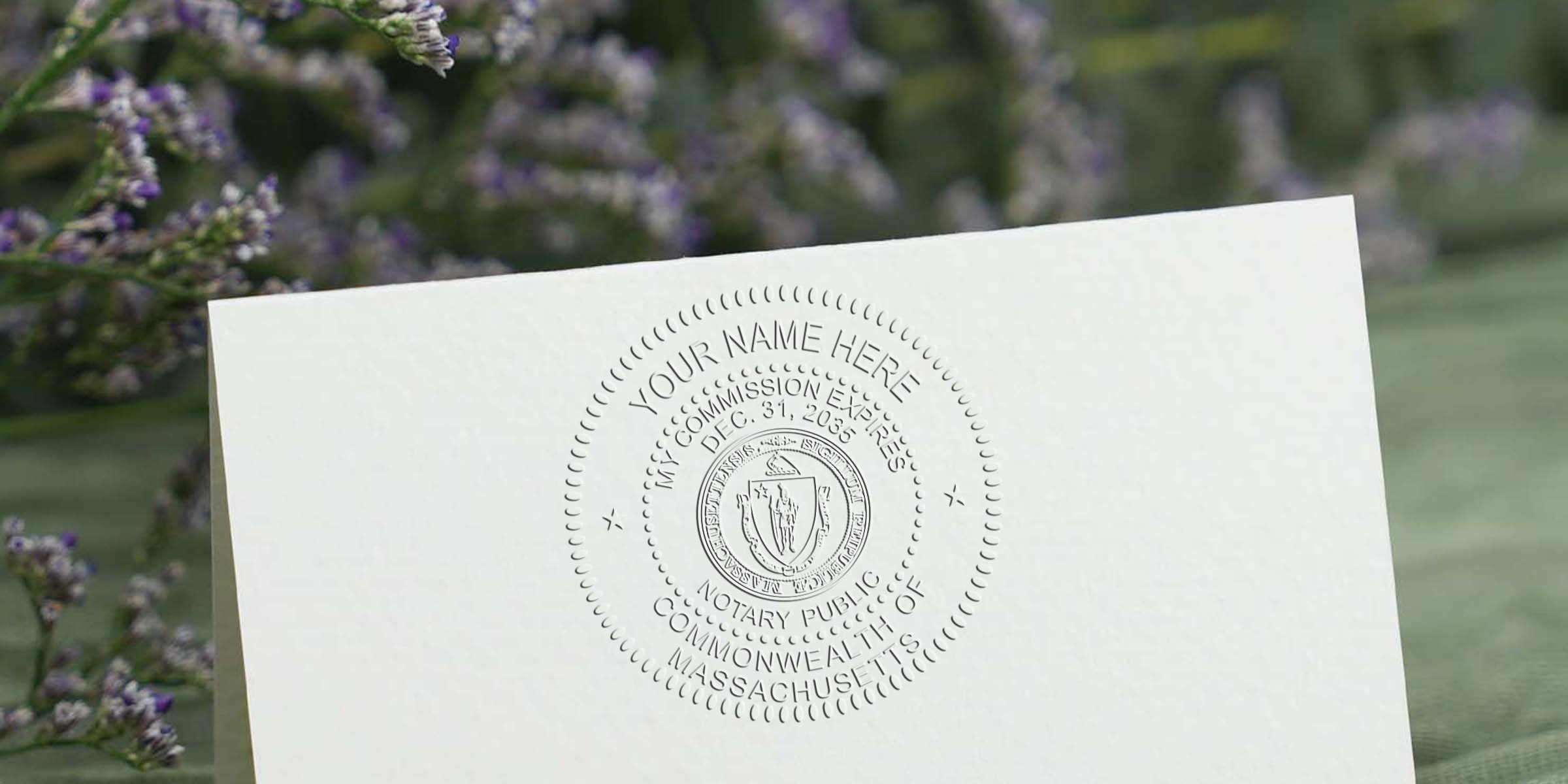 Embossed notary public seal on cream card stock with blank "Your Name Here" text, Commonwealth of Massachusetts official seal, close-up stationery photo with soft green and lavender floral background, professional legal certification texture