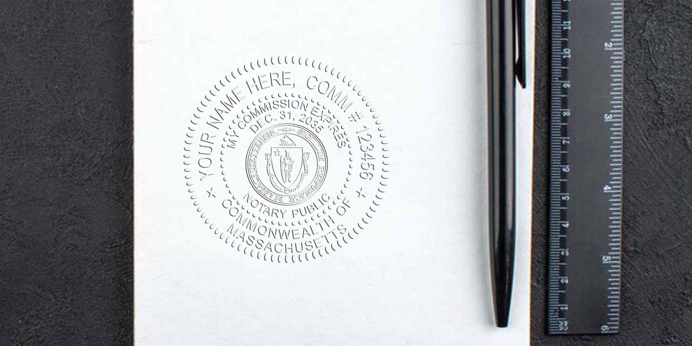 Embossed Massachusetts notary public seal on white paper beside a black pen and ruler on a dark textured desk surface