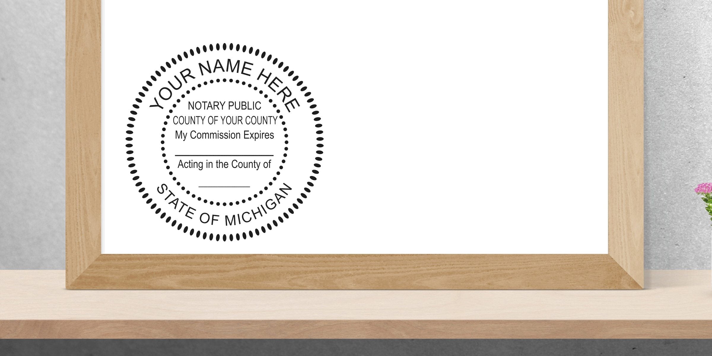 Round Michigan notary public stamp template in black on white, framed in light wood on a shelf, space for name, county and commission expiration dates
