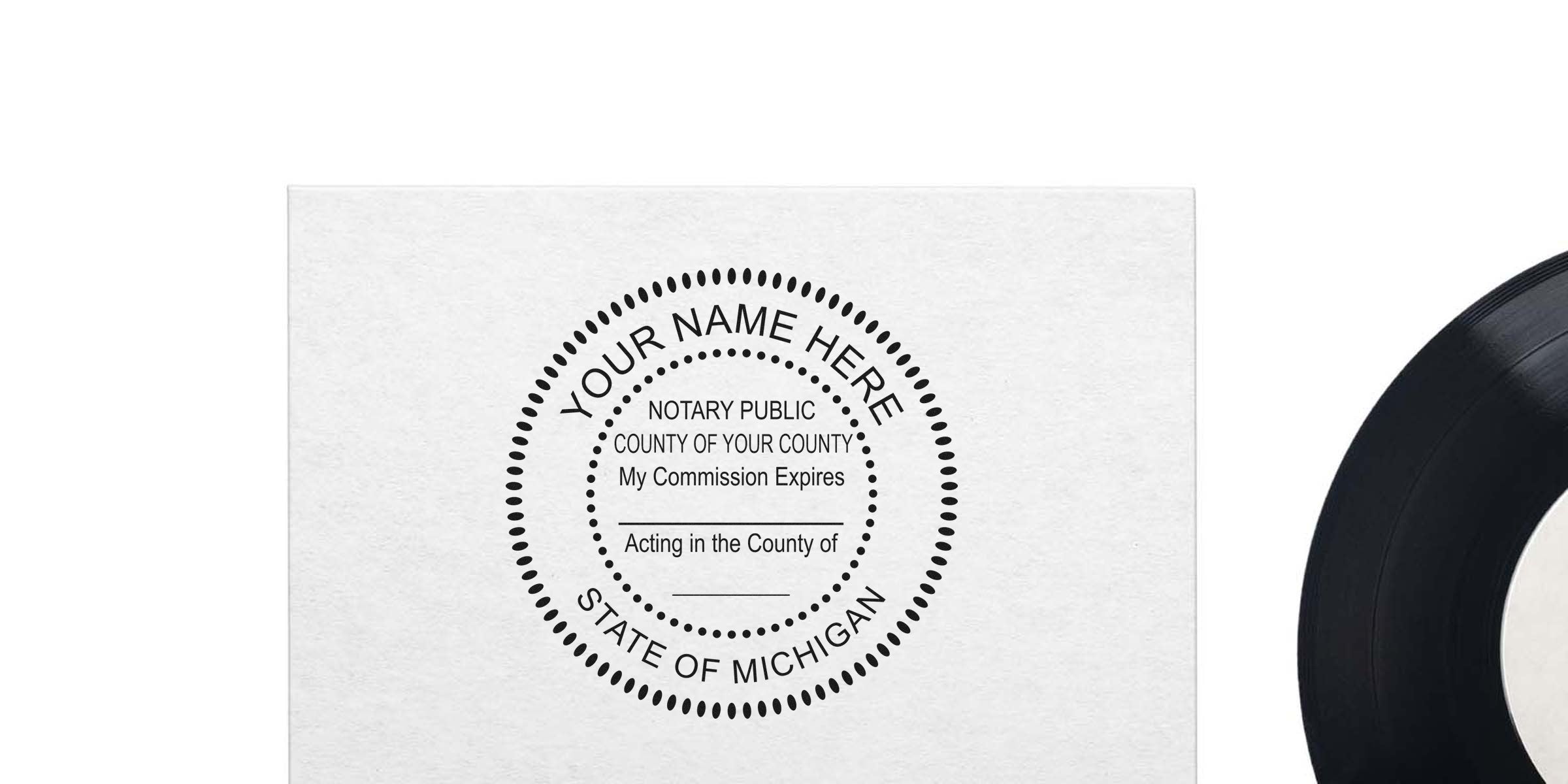 Notary public round stamp template mockup on white paper reading "Your Name Here, State of Michigan" beside a black vinyl record — customizable Michigan notary seal design for business stationery.
