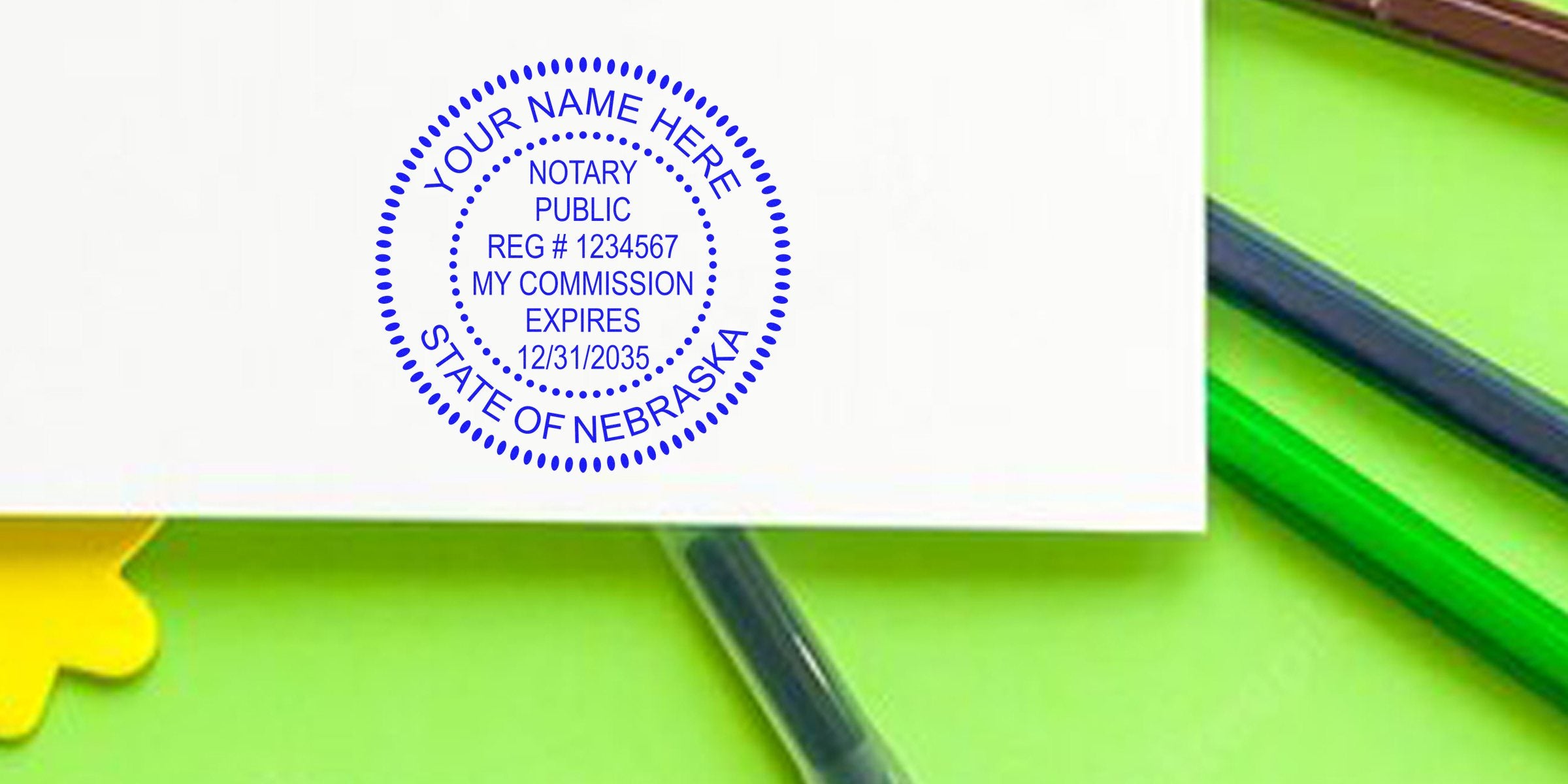Blue circular notary stamp reading "Notary Public, State of Nebraska" printed on white paper with green pencils and a green background.