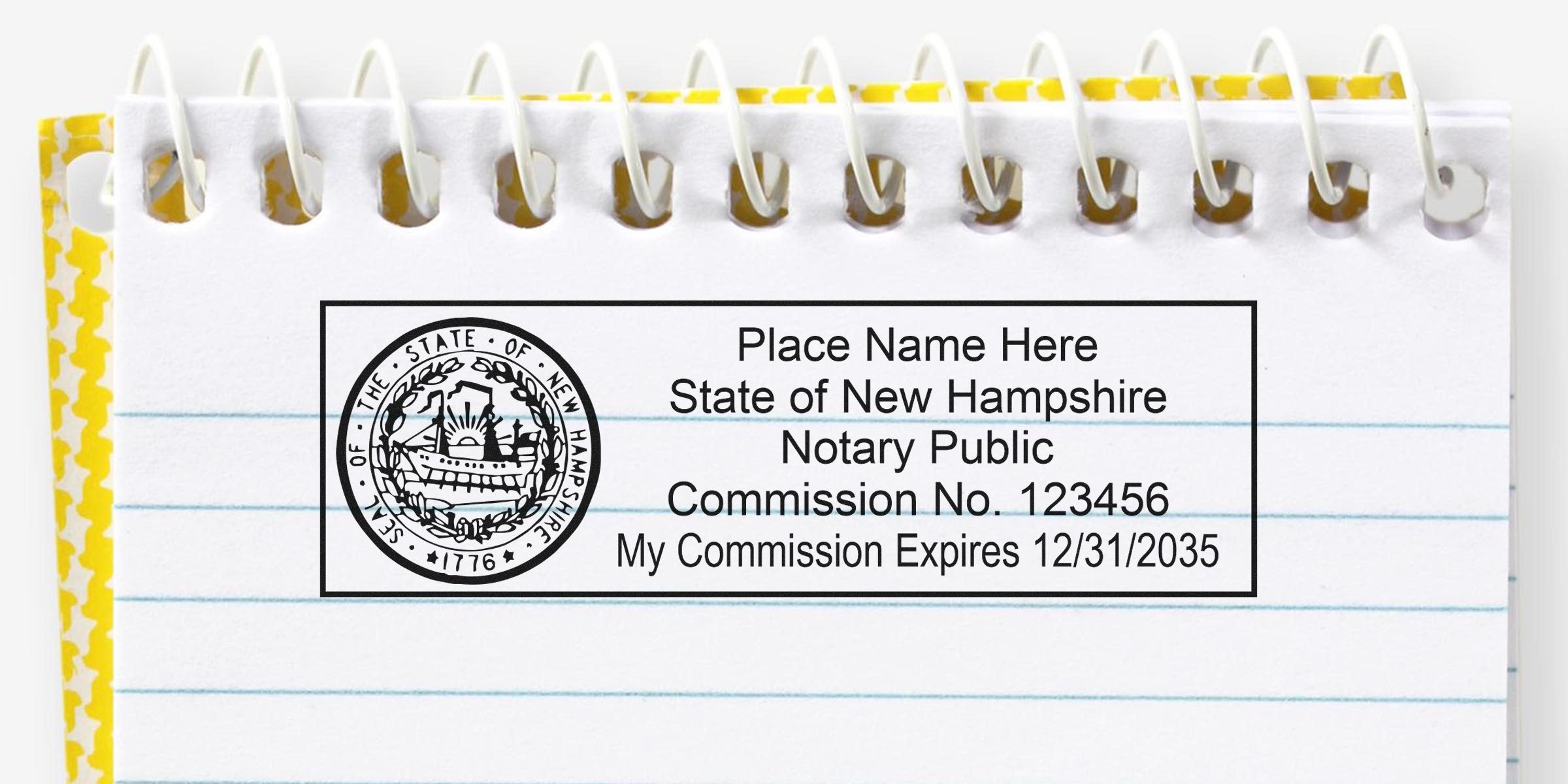 Top-down photo of a New Hampshire notary public rubber stamp impression on a spiral-lined notebook showing state seal, commission no. placeholder and expiration date.