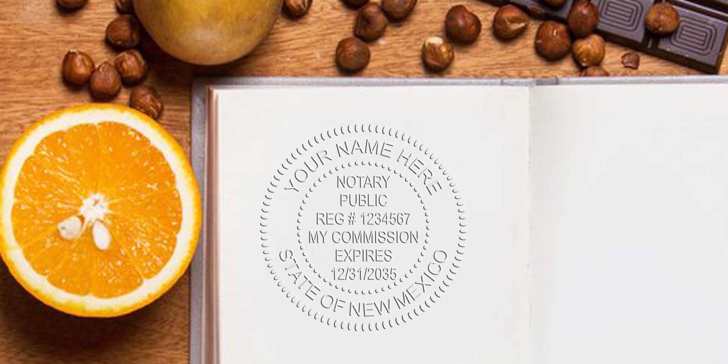 Close-up of an embossed notary public seal on an open notebook page with a halved orange, hazelnuts and chocolate on a wooden table—stationery and food flatlay.