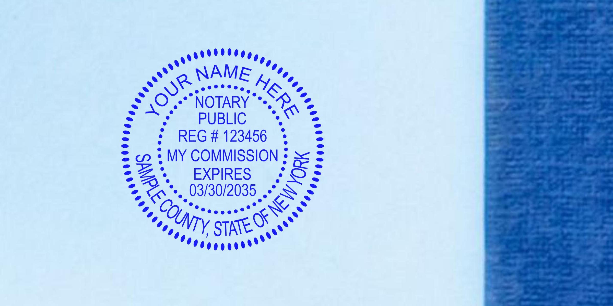 Blue circular notary stamp sample on light blue paper, dotted border reading "YOUR NAME HERE", "NOTARY PUBLIC", registration number and commission expires date, blue textured margin at right.
