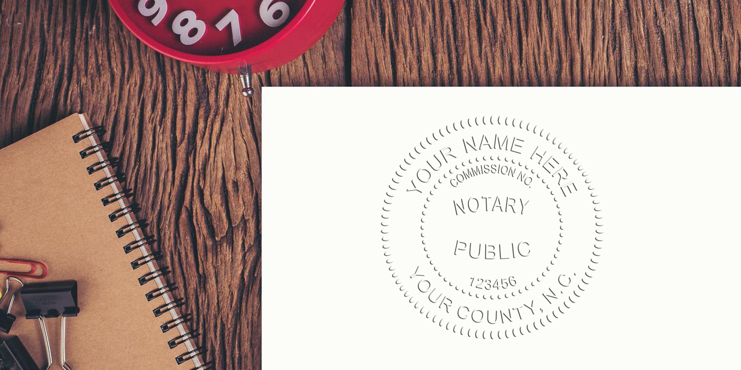 Wooden desk with spiral notebook, binder clips and red alarm clock beside white paper embossed with a circular Notary Public seal, notary seal close-up