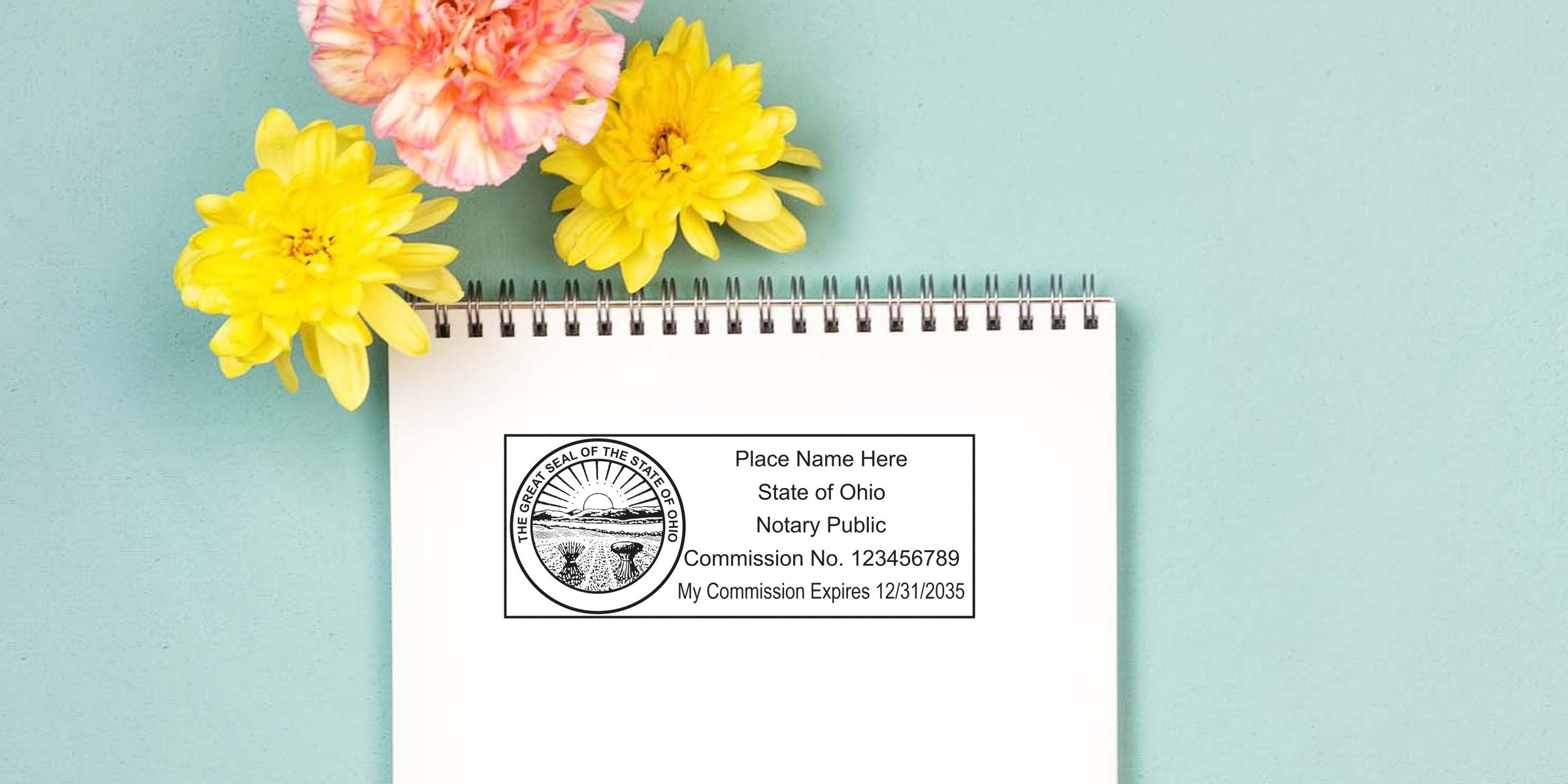Blank spiral notebook page showing Ohio notary public rubber stamp mockup with commission number and expiration date, styled on teal background with yellow and pink flowers for stationery or legal document branding