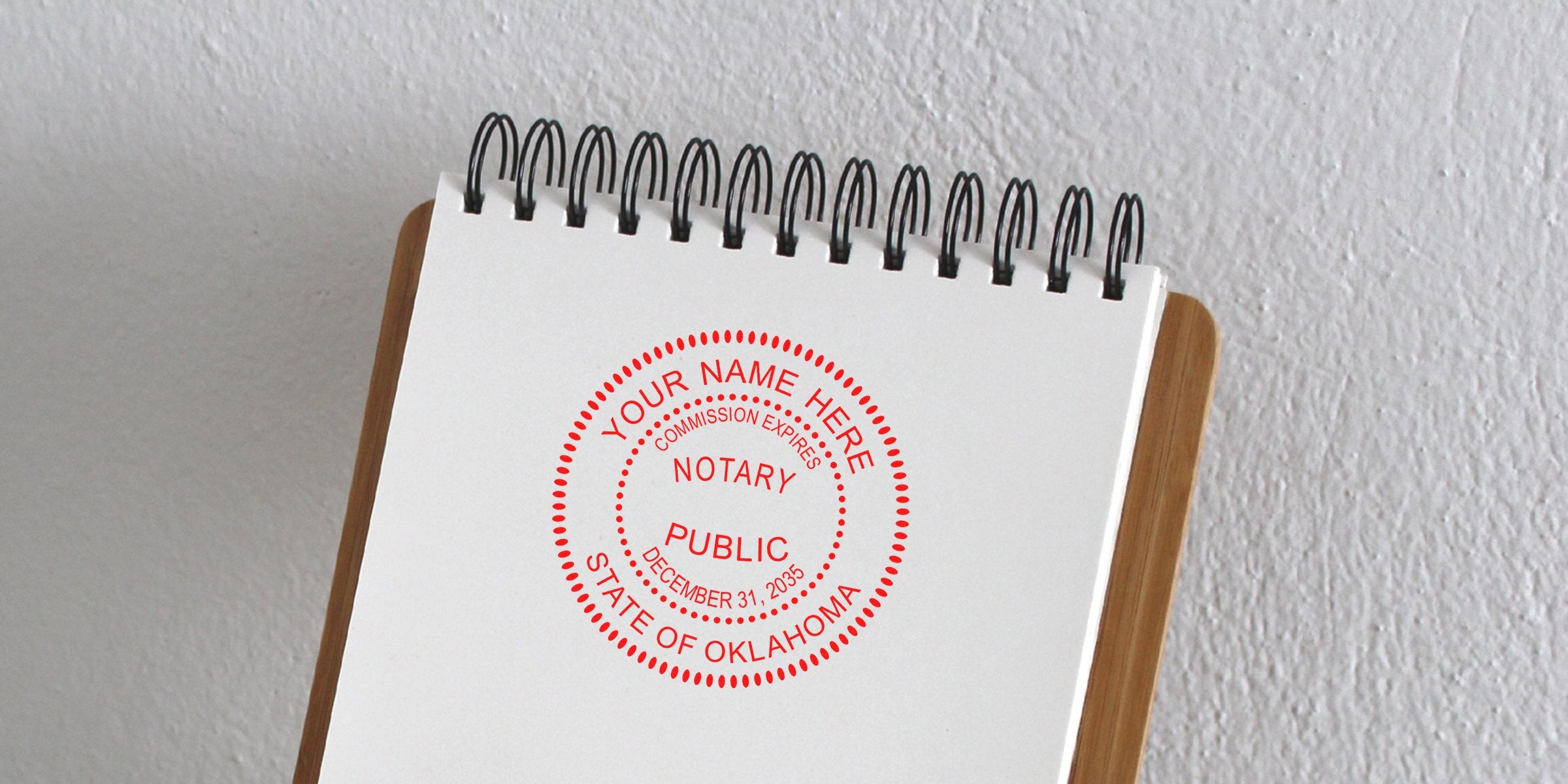 Red circular Notary Public stamp reading "Your Name Here" and "State of Oklahoma" printed on a white spiral-bound notebook page.