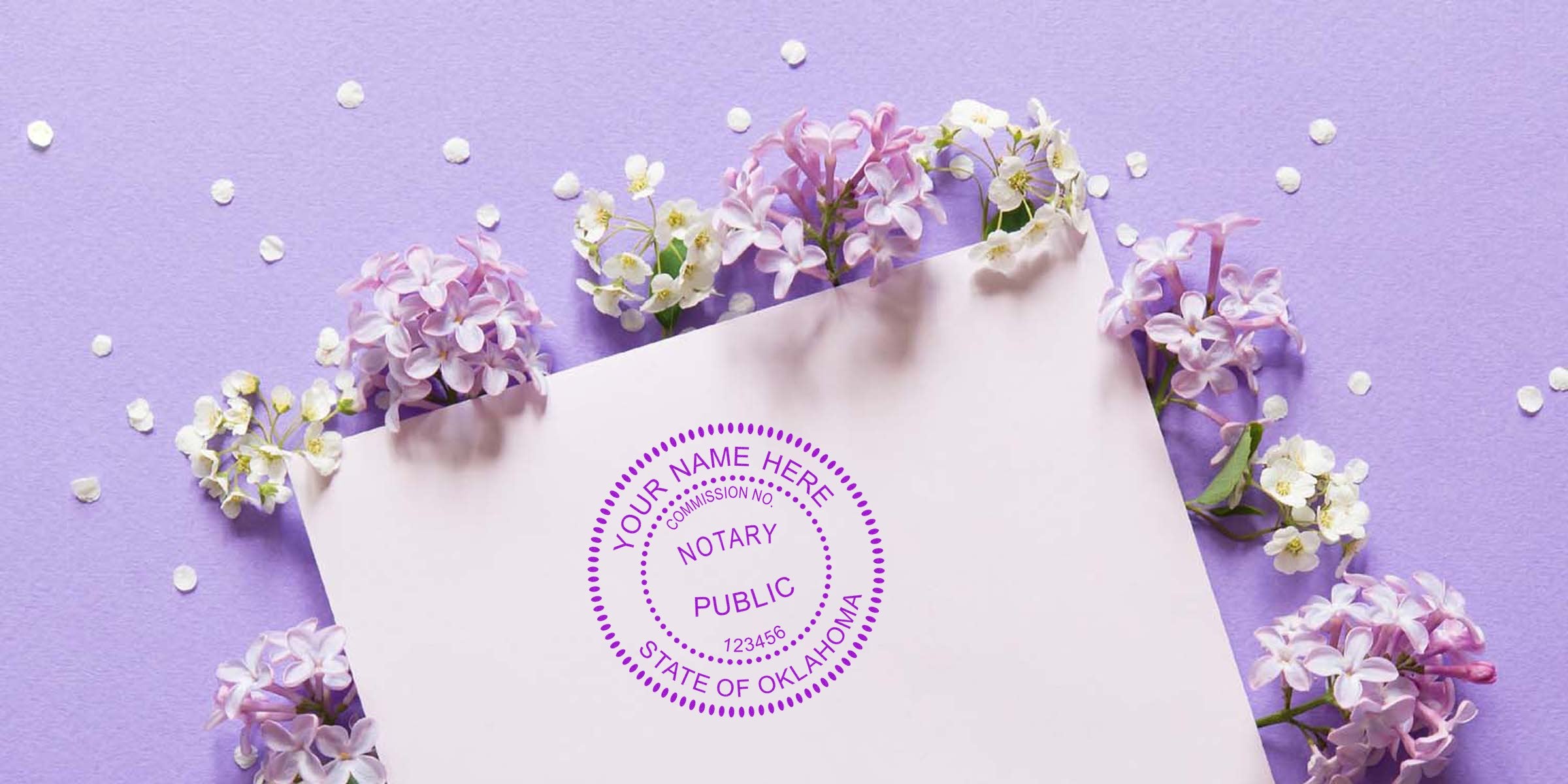 Purple circular notary public stamp on pale pink paper surrounded by lilac and white spring flowers on a lavender background — floral stationery mockup highlighting an Oklahoma notary seal.
