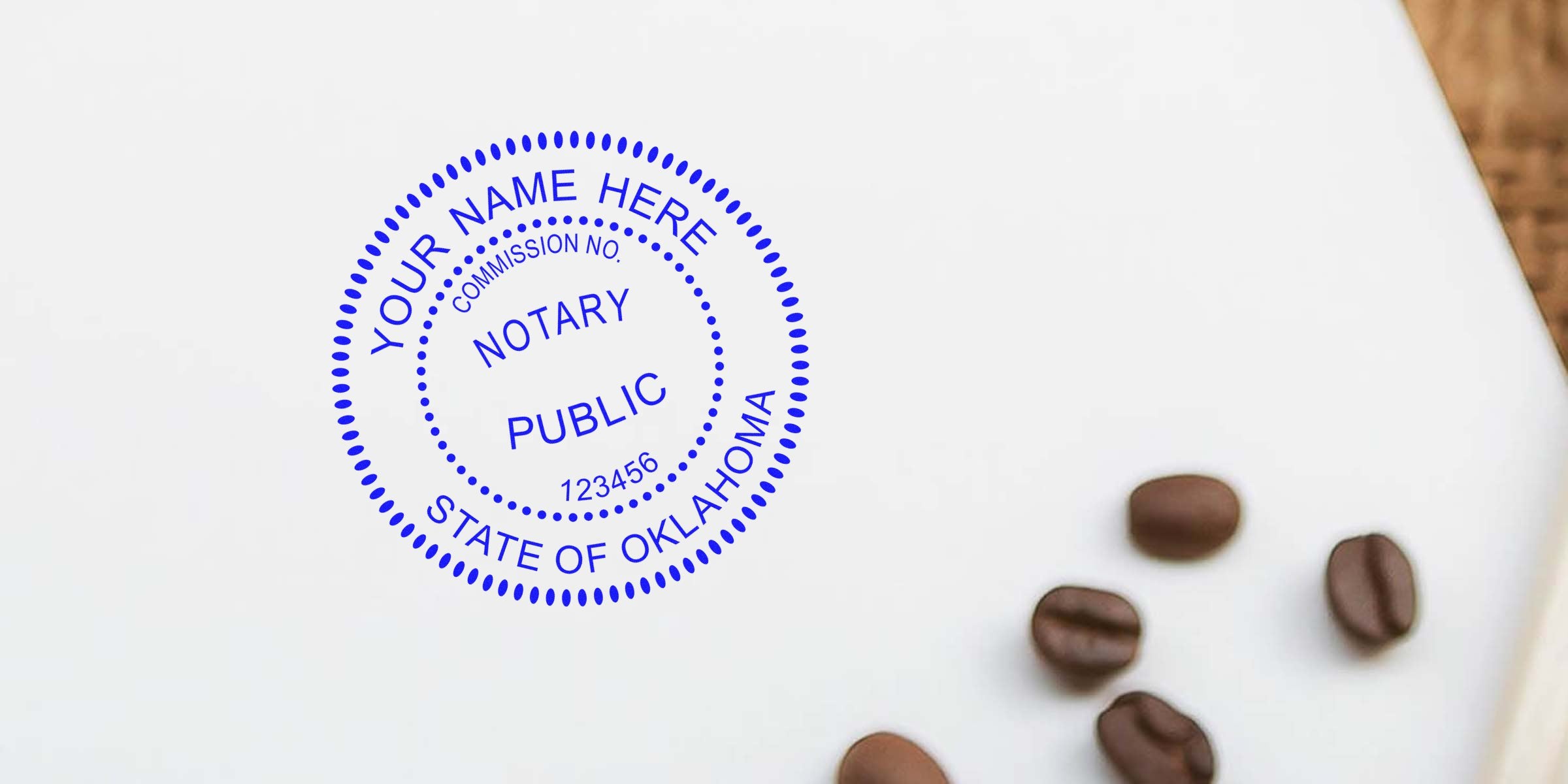 Blue notary public stamp mockup reading "Your Name Here, State of Oklahoma" on white background with scattered coffee beans, flatlay