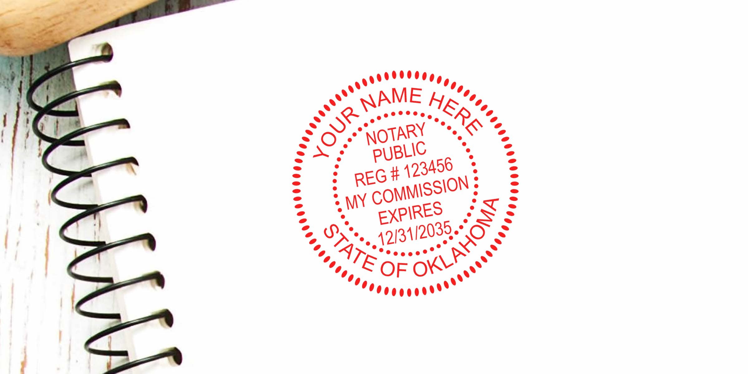 Red circular notary public stamp on white paper showing sample registration number, commission expiration date and "State of Oklahoma" next to a black spiral-bound notebook edge