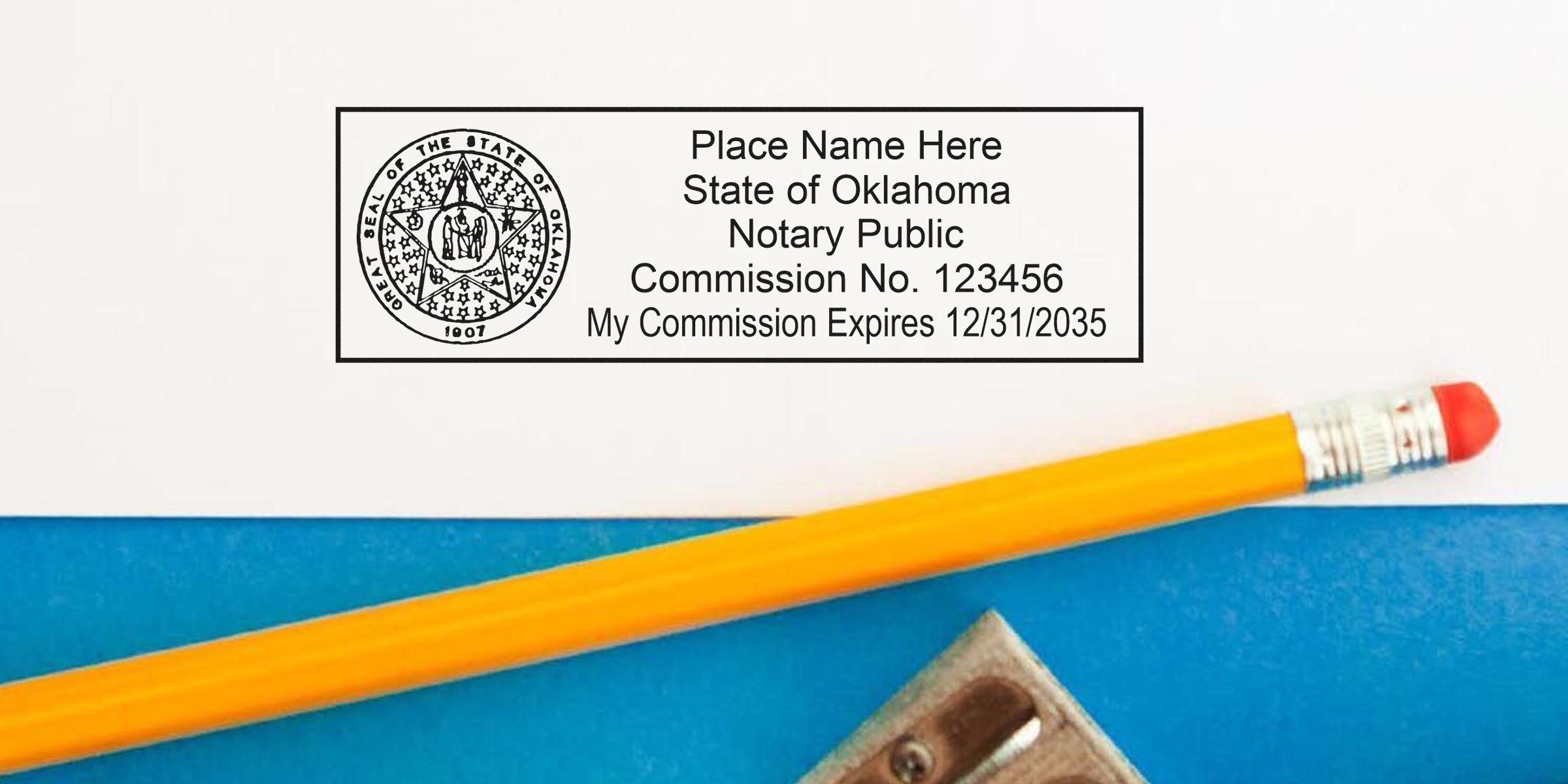 Close-up of Oklahoma notary public stamp on white paper showing state seal and commission details, yellow pencil and metal sharpener on blue background