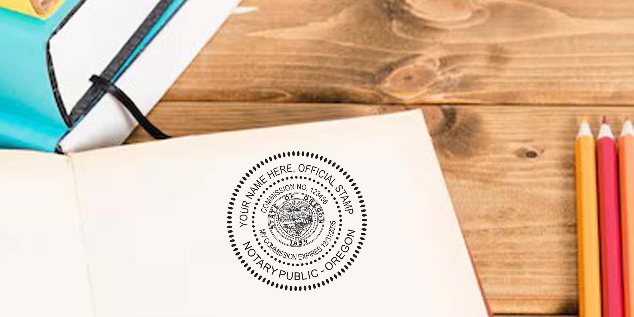 Open notebook on wooden desk featuring a round Oregon notary public seal imprint, colored pencils on the right and a teal zippered notebook pouch at top left — stationery scene for notary services, legal documents, or office supplies.