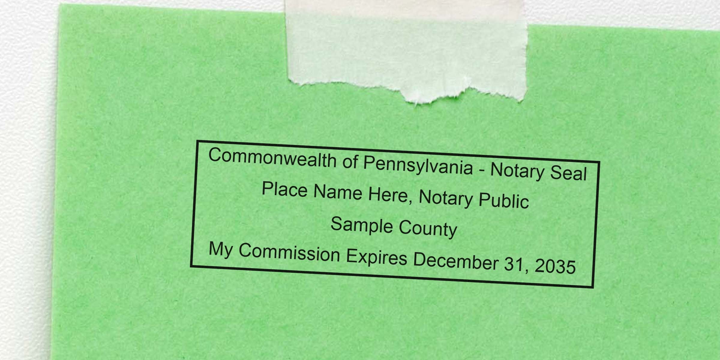 Green paper with a rectangular Commonwealth of Pennsylvania notary seal stamp reading placeholder name, Sample County, and commission expires December 31, 2035, taped to white background