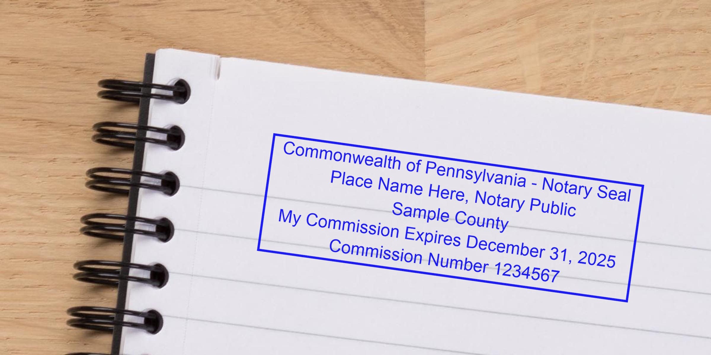 Spiral-bound notebook page with a blue rectangular Pennsylvania notary seal stamp showing sample text: "Commonwealth of Pennsylvania - Notary Seal," sample county, commission expiration date and commission number.