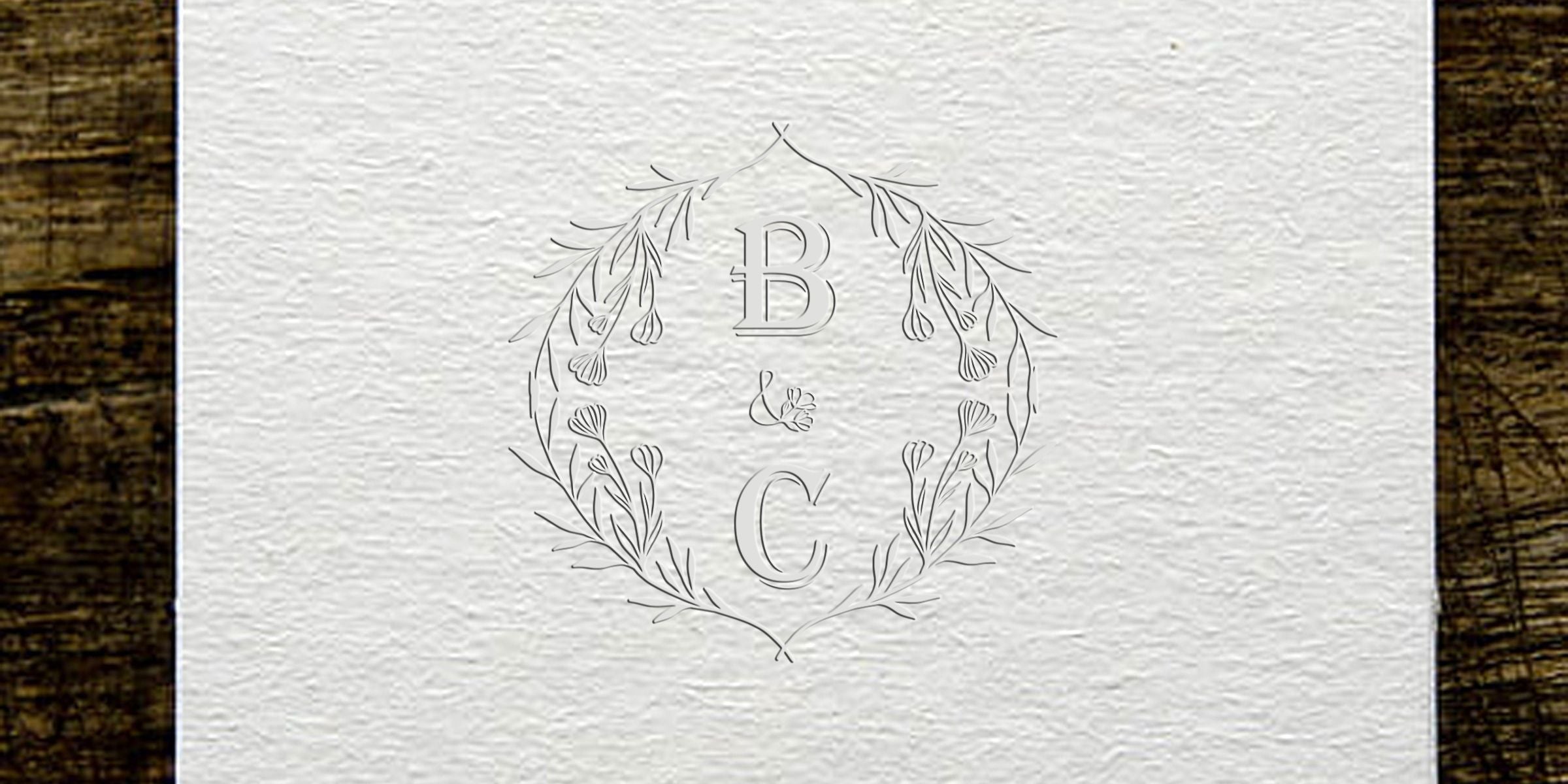 Elegant logo with the letters B and C, a central ampersand, and a delicate circular botanical wreath.