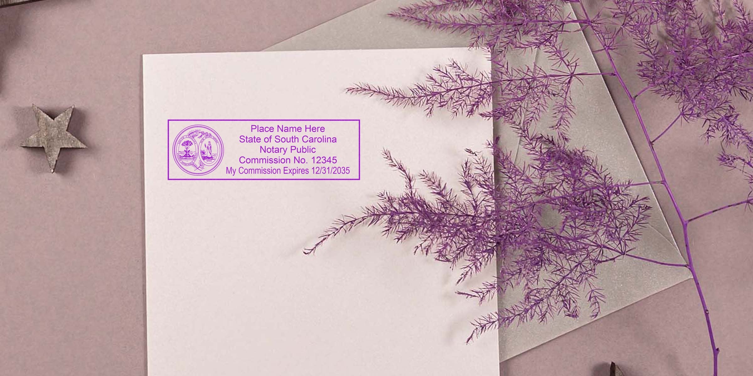 Flat lay envelope with South Carolina notary public stamp in purple ink, decorative purple fern sprig and wooden star on mauve background
