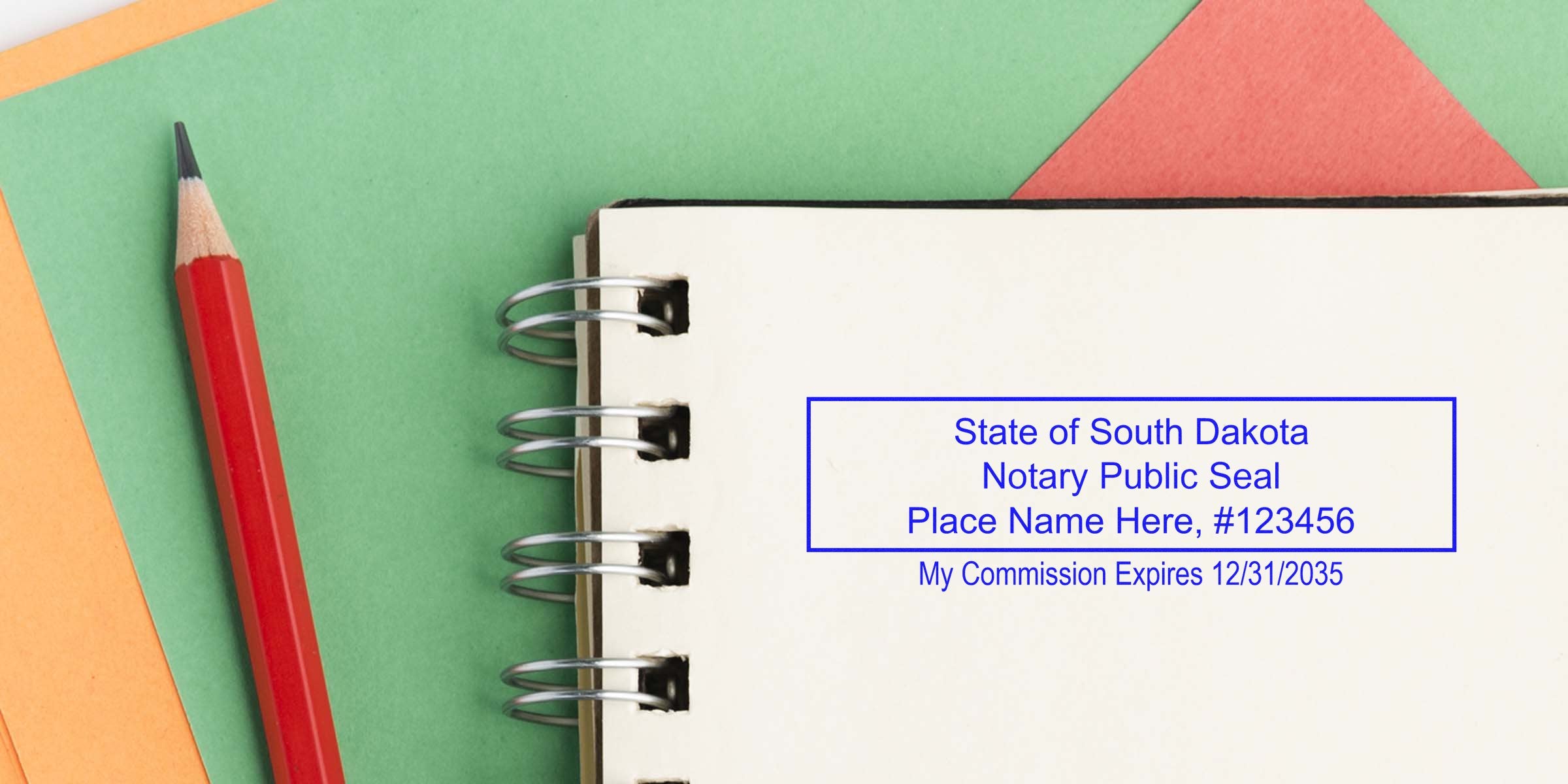 South Dakota notary public seal stamp on a spiral notebook page with sample name and commission expiration, red pencil and green-orange paper background