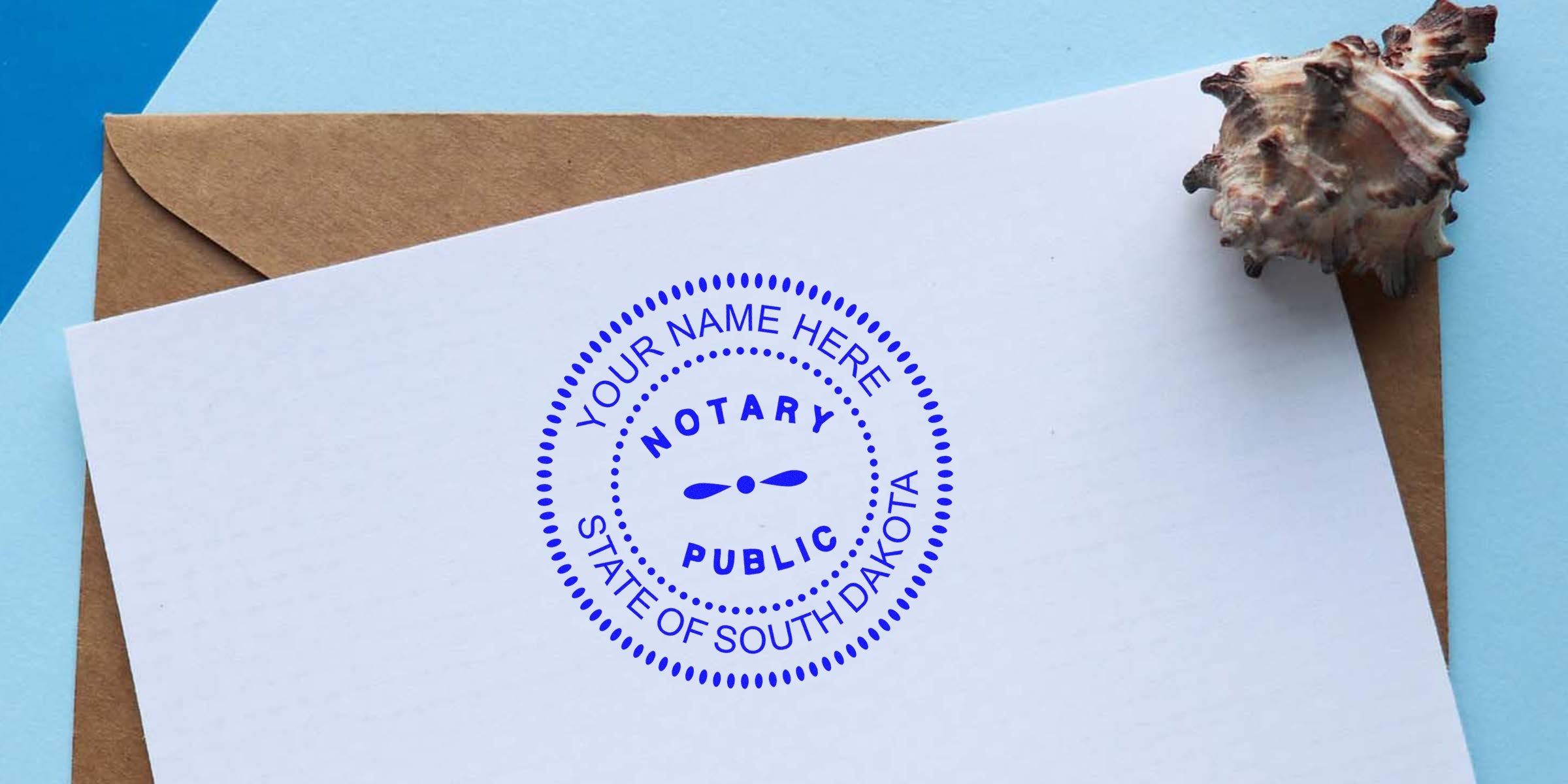 Blue circular "Notary Public" seal stamped "Your Name Here, State of South Dakota" on white stationery resting on a brown envelope and blue background with a seashell prop — custom notary stamp concept for South Dakota documents.