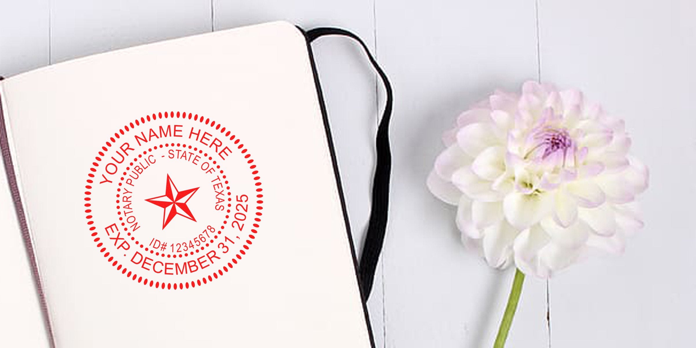 Open notebook with a red Texas notary public seal stamp mockup on a blank page beside a white dahlia flower on a white wooden background