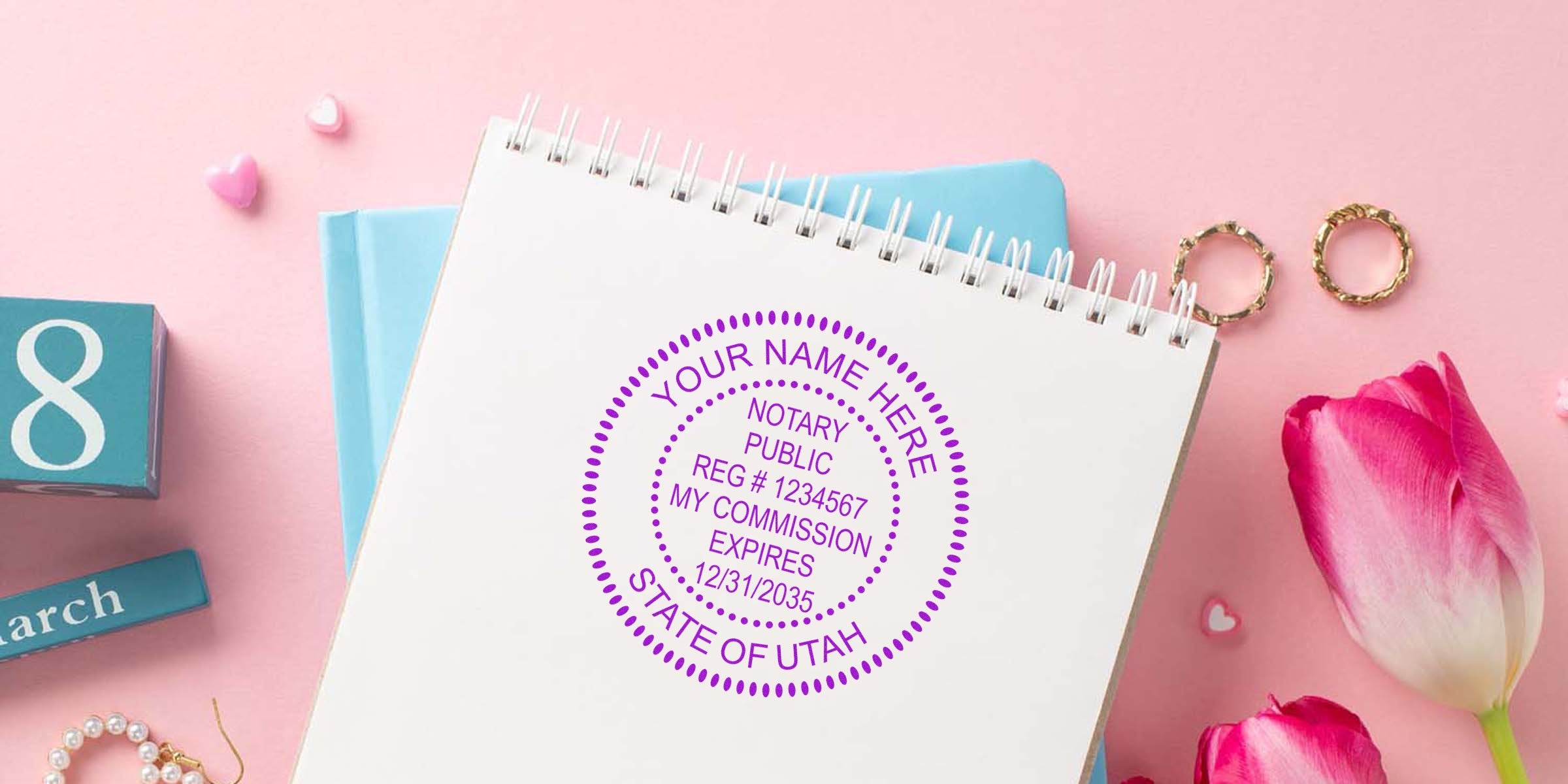Purple circular notary stamp mockup on spiral notebook over pink background with tulips, gold rings and a March calendar block