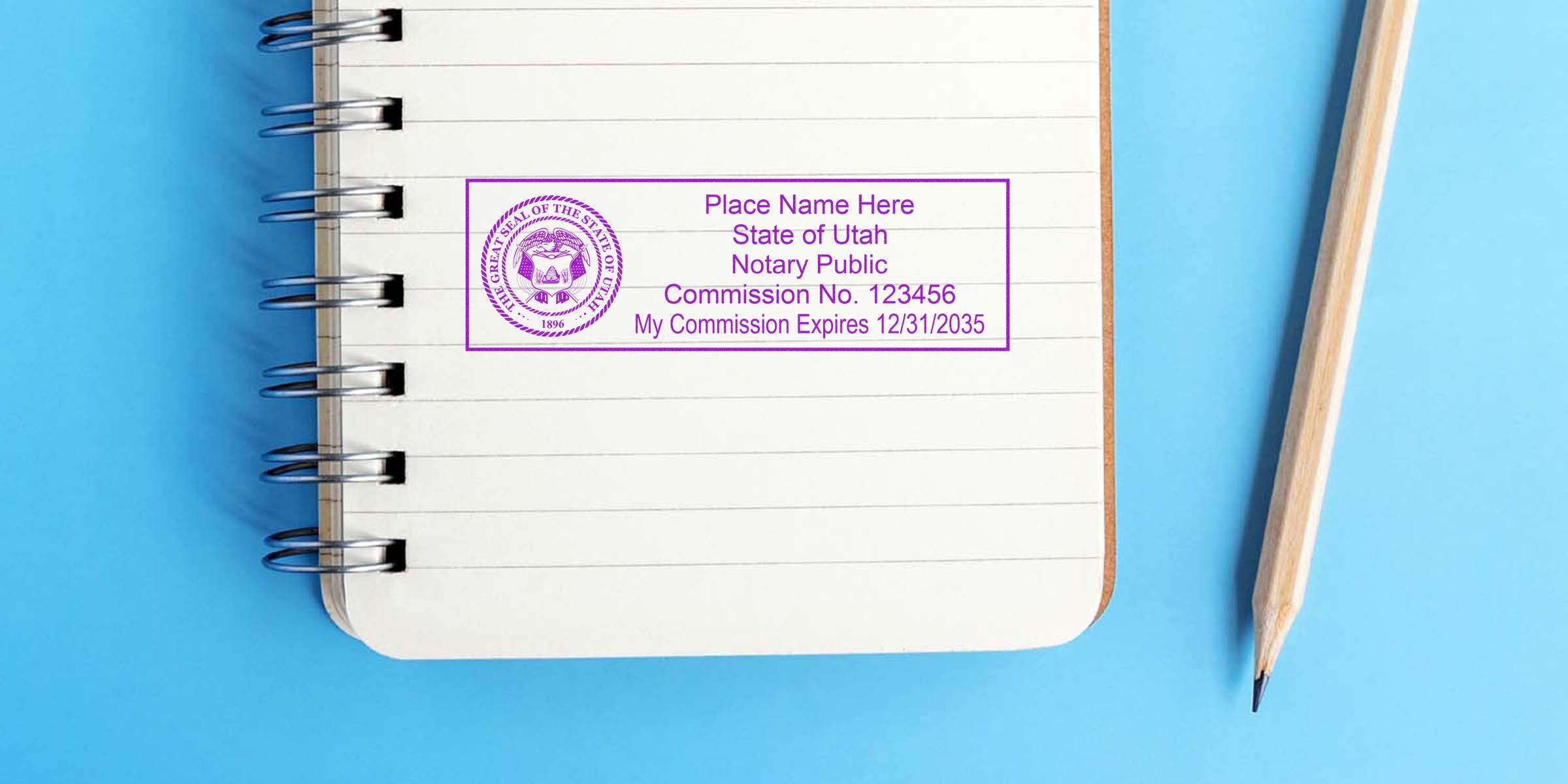 Top-down view of spiral notebook with lined pages and a purple Utah notary public stamp template, wooden pencil on blue background, blank space for name, commission number and expiration date.