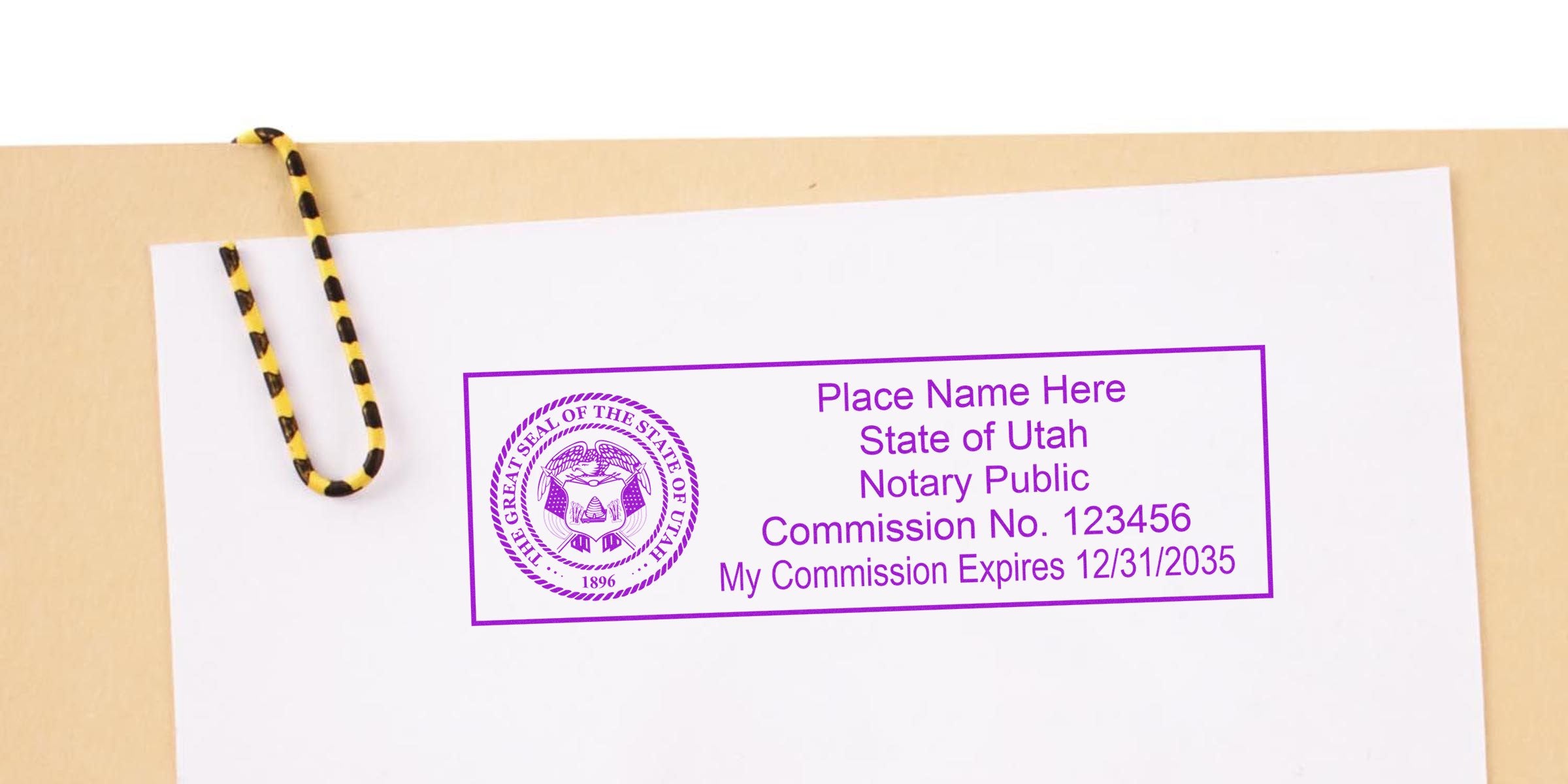 White paper with purple Utah notary public stamp mockup showing state seal, placeholder name, commission number and expiration date, clipped by a yellow-and-black striped paperclip on a beige folder background