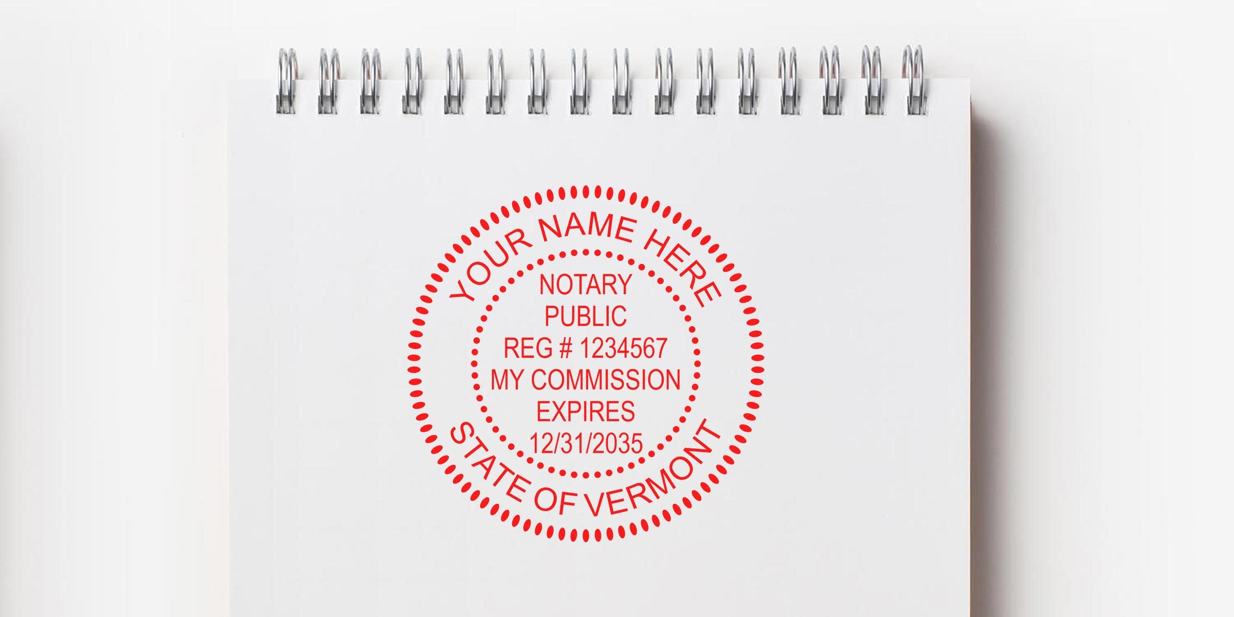 Red circular Vermont notary public stamp on white spiral-bound notepad showing registration #1234567 and commission expiration 12/31/2035