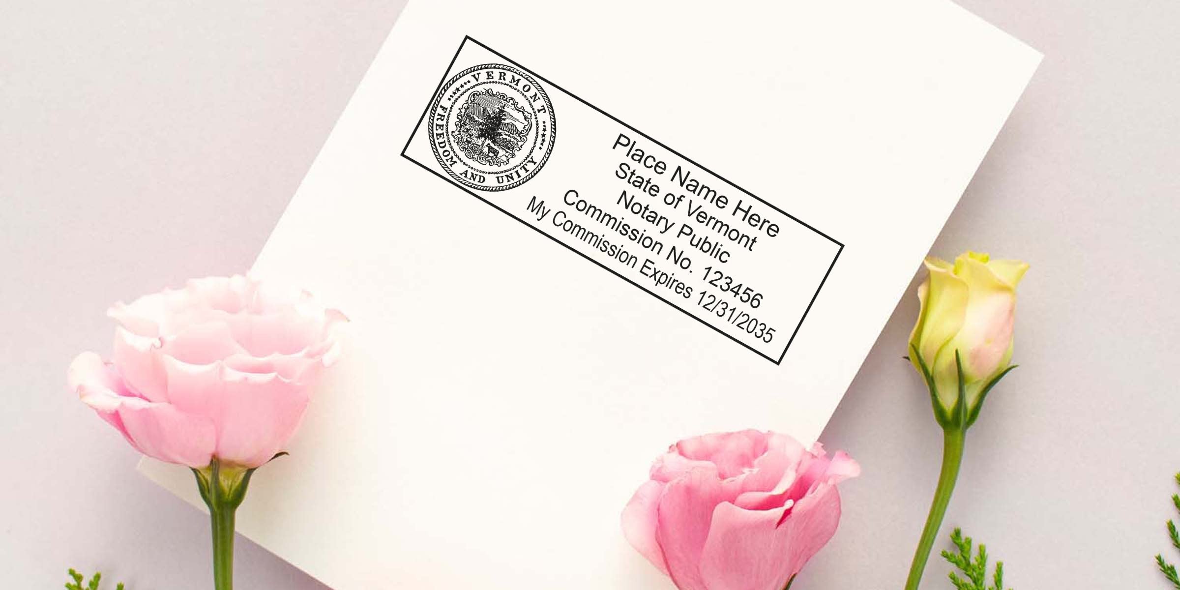 White envelope with Vermont notary public stamp in black ink beside pink and pale-yellow roses on a soft pastel background