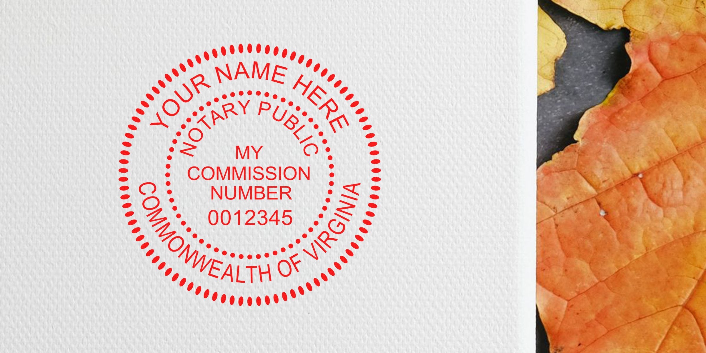 Red circular notary seal stamp reading "Notary Public, Commonwealth of Virginia, My Commission Number 0012345" printed in red on textured white paper beside an orange autumn leaf.