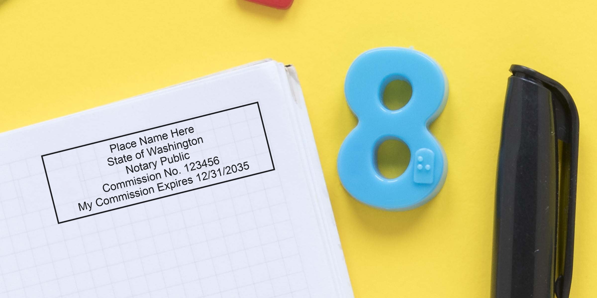 Notary public commission stamp sample on grid paper showing placeholder name, commission number and expiration date, beside a blue number 8 magnet and black stapler on a bright yellow background