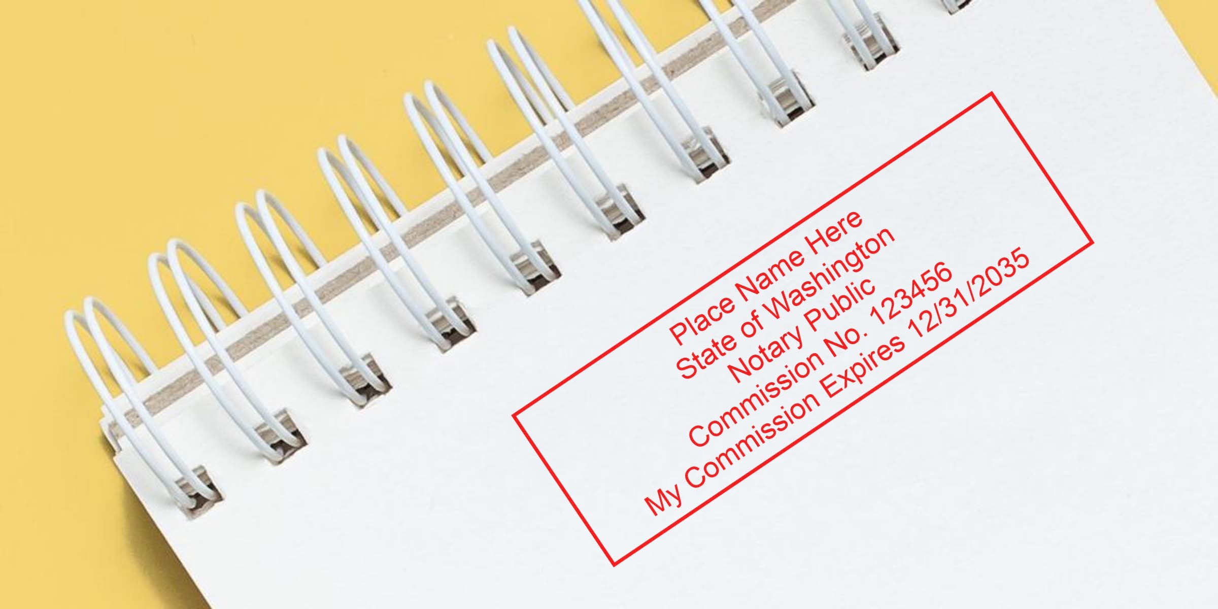 Close-up of a white spiral-bound notebook on a yellow background featuring a red rectangular notary stamp placeholder with text for name, State of Washington, notary public, commission number and expiration date.