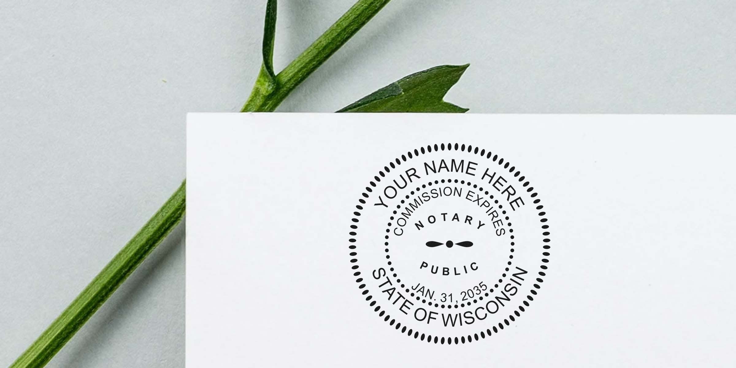 Close-up of a white card showing a circular black notary public stamp mockup reading "Your Name Here," "Commission Expires Jan. 31, 2035," "State of Wisconsin," with a green plant stem on a gray background.