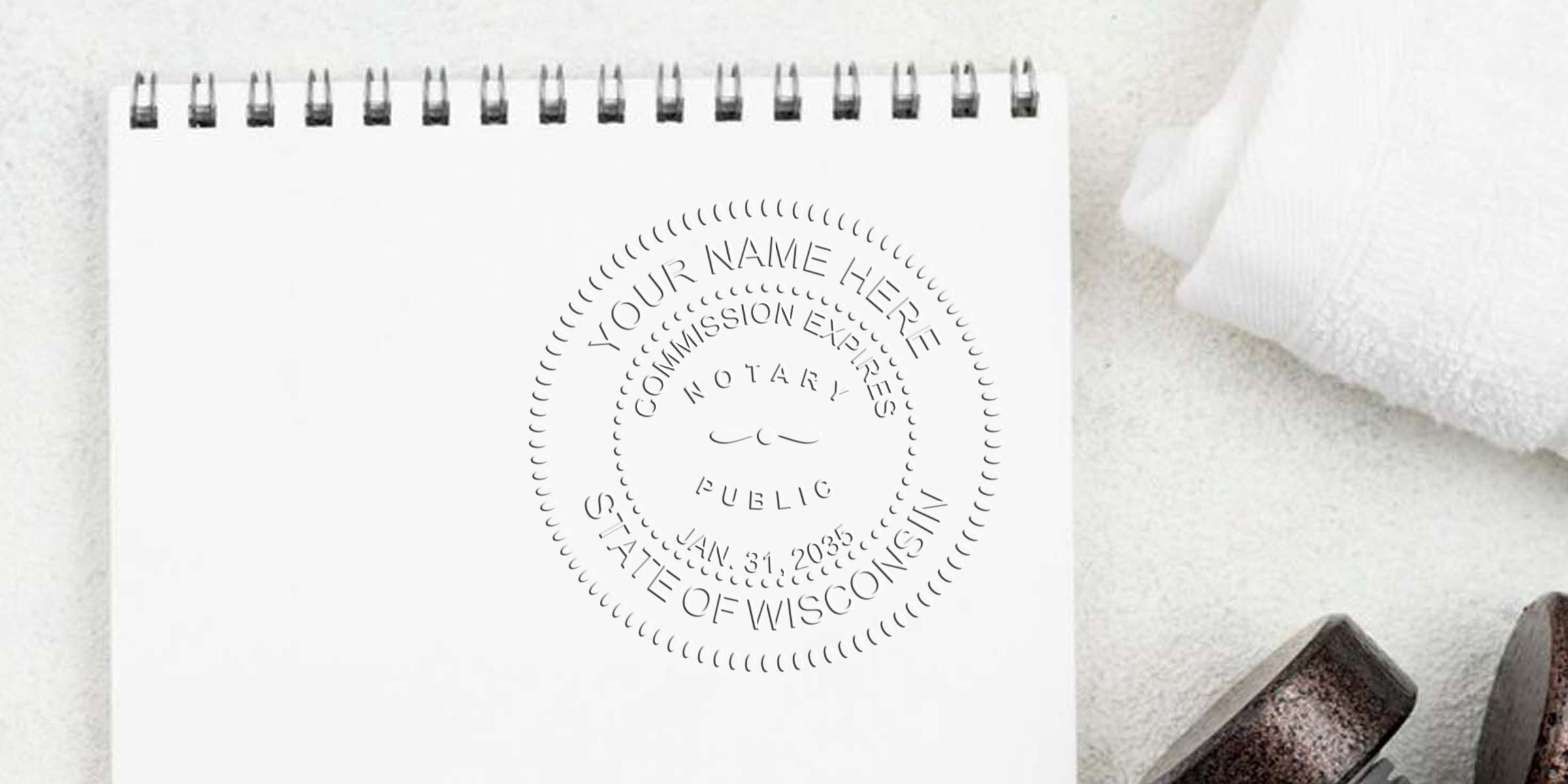 Mockup of embossed notary public seal reading "Your Name Here, State of Wisconsin" on a blank spiral-bound notebook page, with a rolled towel and dumbbell nearby — notary seal branding mockup for Wisconsin notaries