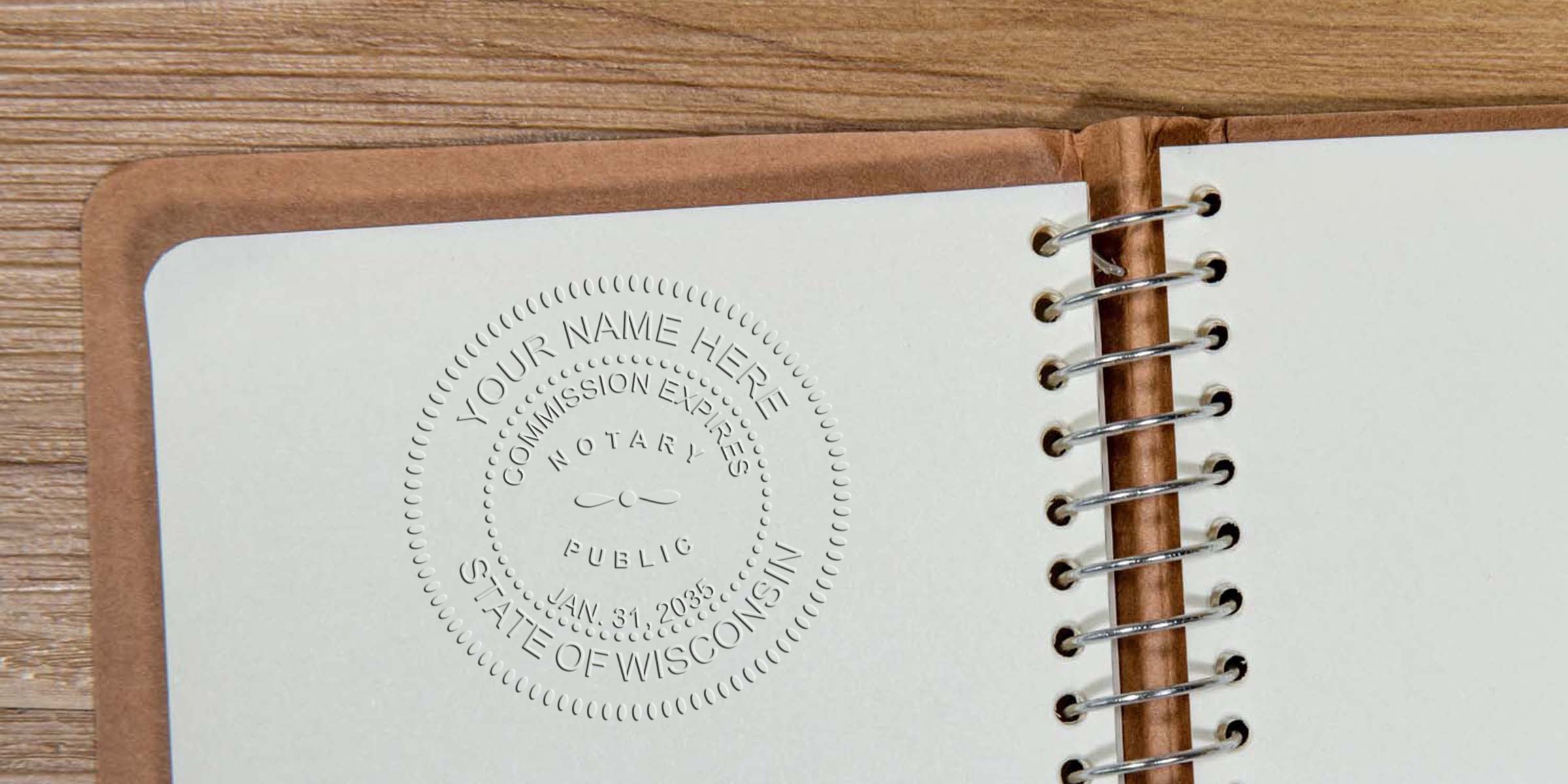 Embossed notary seal reading "State of Wisconsin" impressed on blank notebook page beside metal spiral binding on wood surface