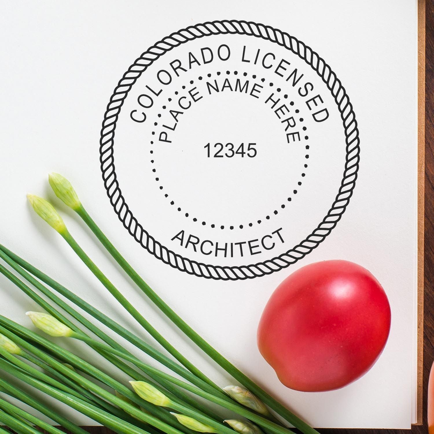 Unlock Your Professional Potential: Colorado Architect Stamps Feature Image - A Colorado licensed architect stamp next to green onions and a tomato.