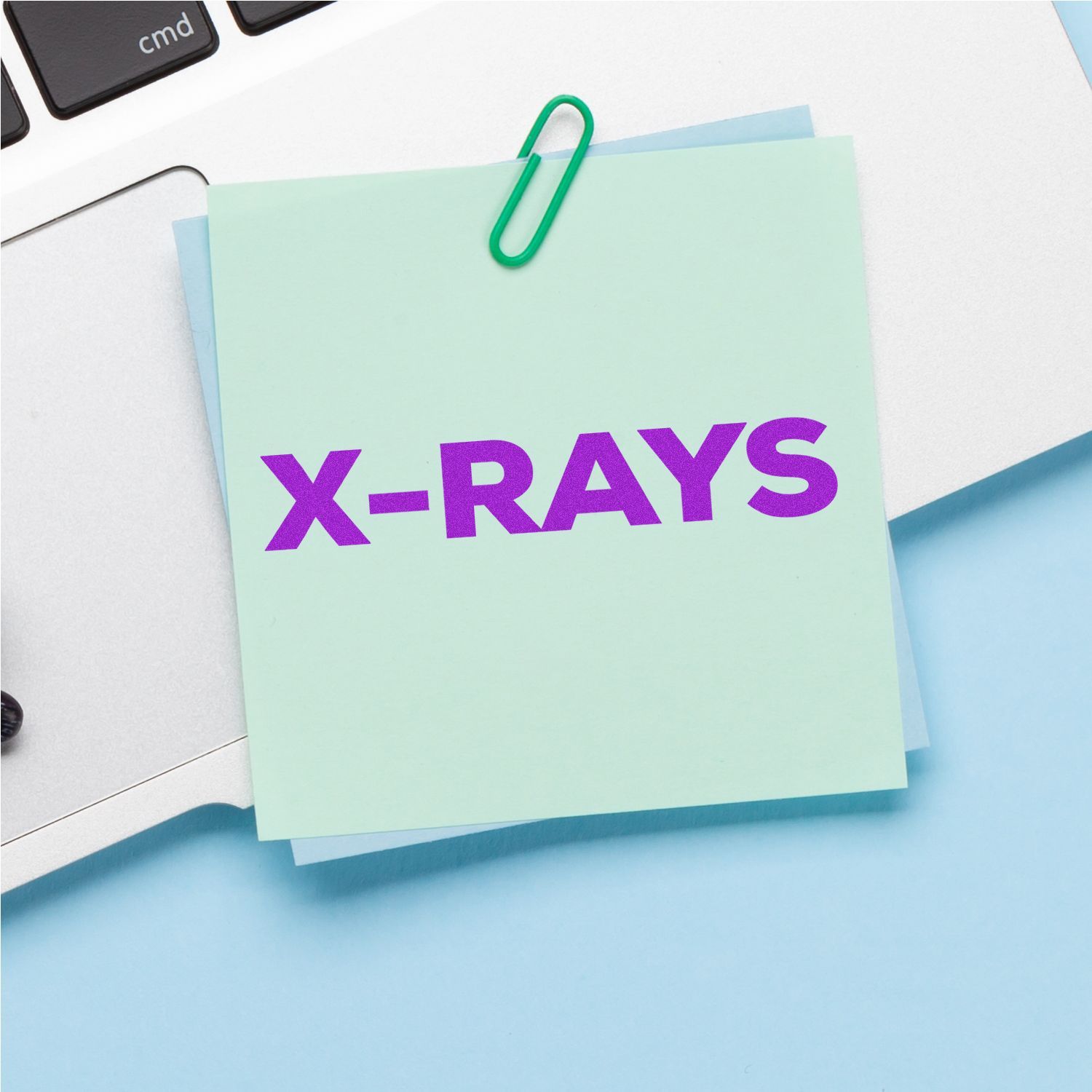 Medical Provider Stamps Blog Post Feature Image: A sticky note with 'X-RAYS' in bold purple letters clipped to a laptop keyboard.