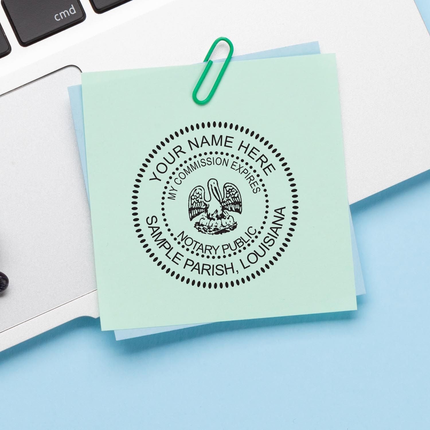 A note clipped to a laptop with a paperclip displays a notary public seal in circular design from Louisiana Notary Supplies.