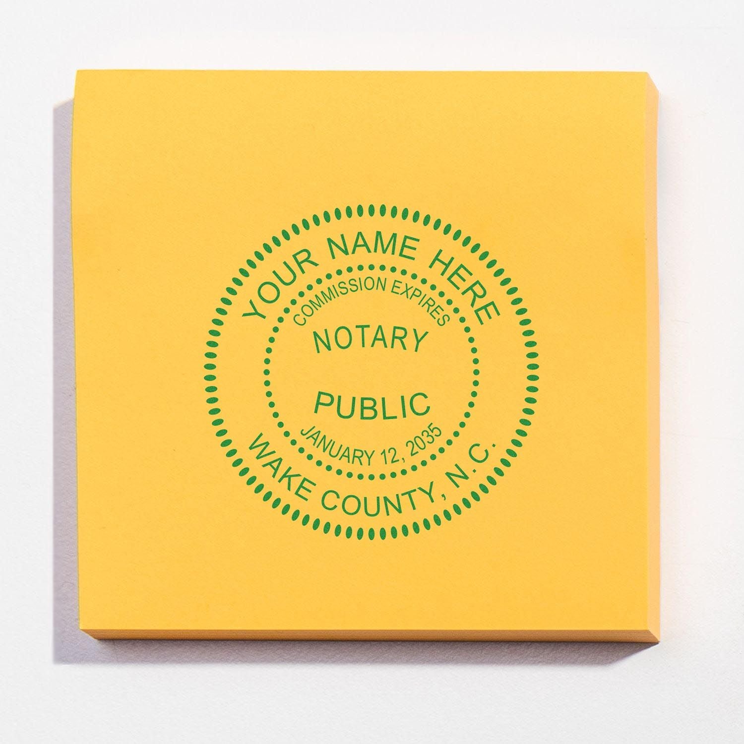 North Carolina Notary Supplies Blog Post Feature Image: A yellow notary stamp with green text for Wake County, N.C., on a white background.